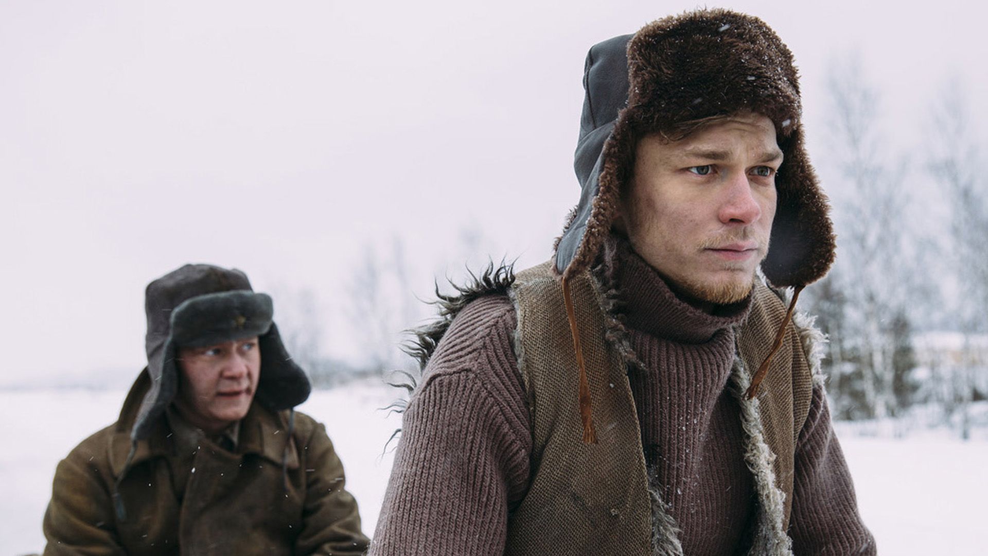 Юра Борисов в ушанке на фоне снежного пейзажа, сериал "Отчий берег"