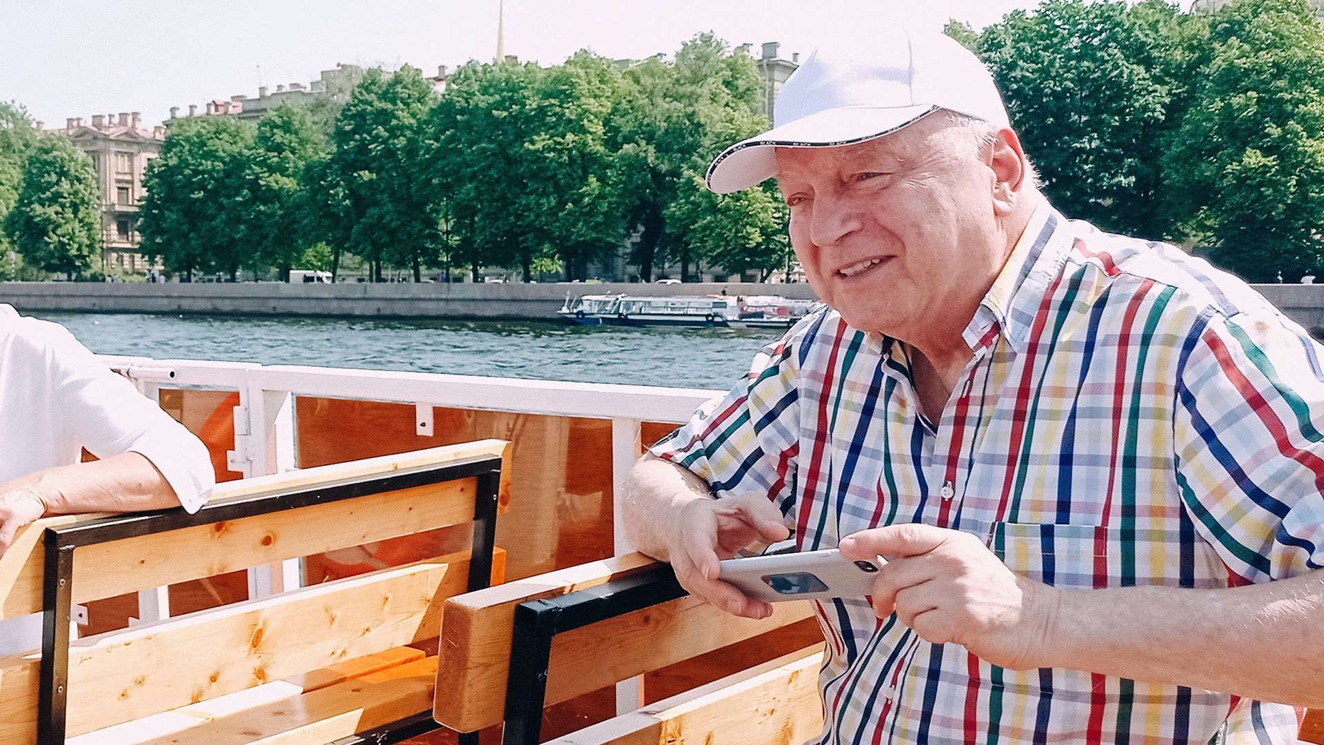 Пожилой Сергей Никитин в клетчатой рубашке и белой кепке на теплоходе
