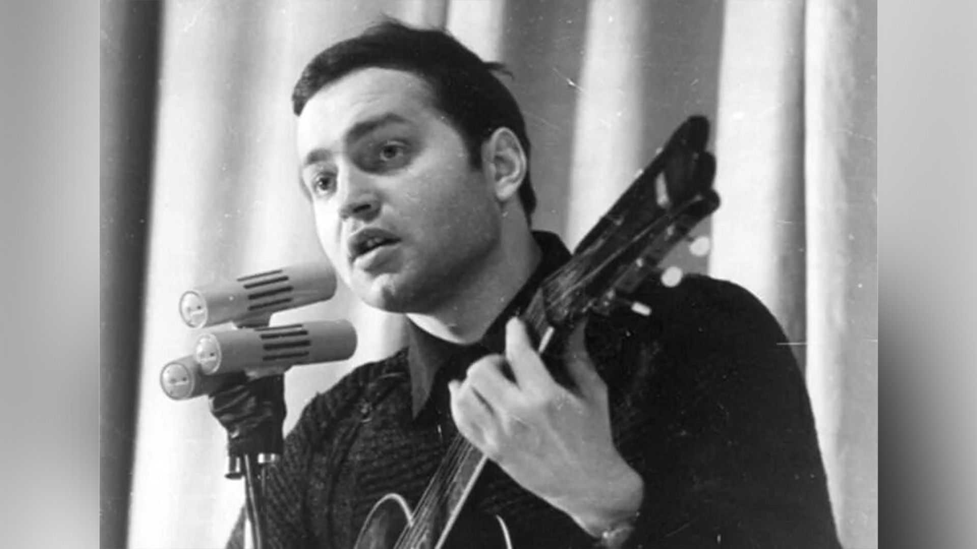 Молодой Сергей Никитин с гитарой, поёт в микрофон на сцене