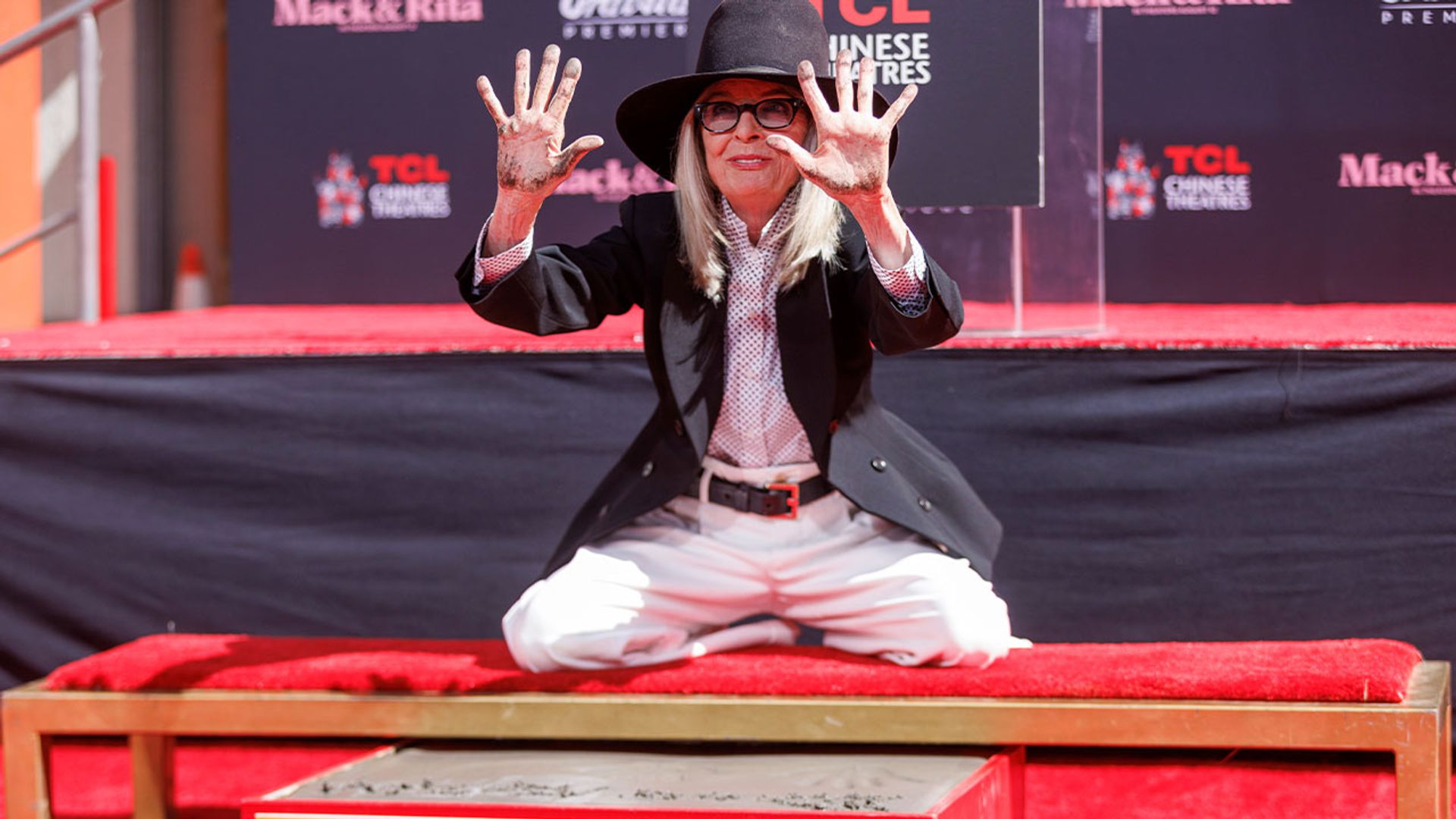 Дайан Китон в шляпе и брючном костюме оставляет в бетоне отпечатки рук