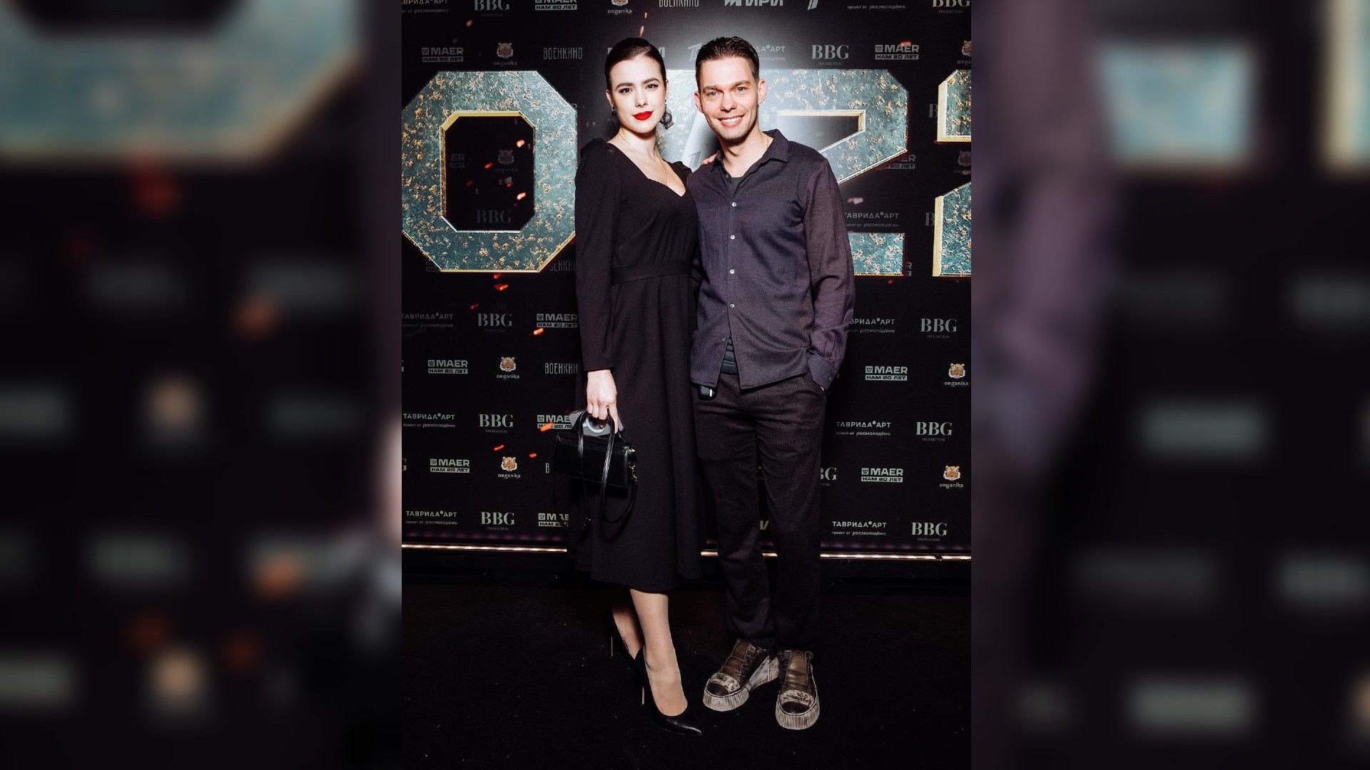 Аристарх Венес и Дарья Кукарских в полный рост на фоне стены с надписью 20/22