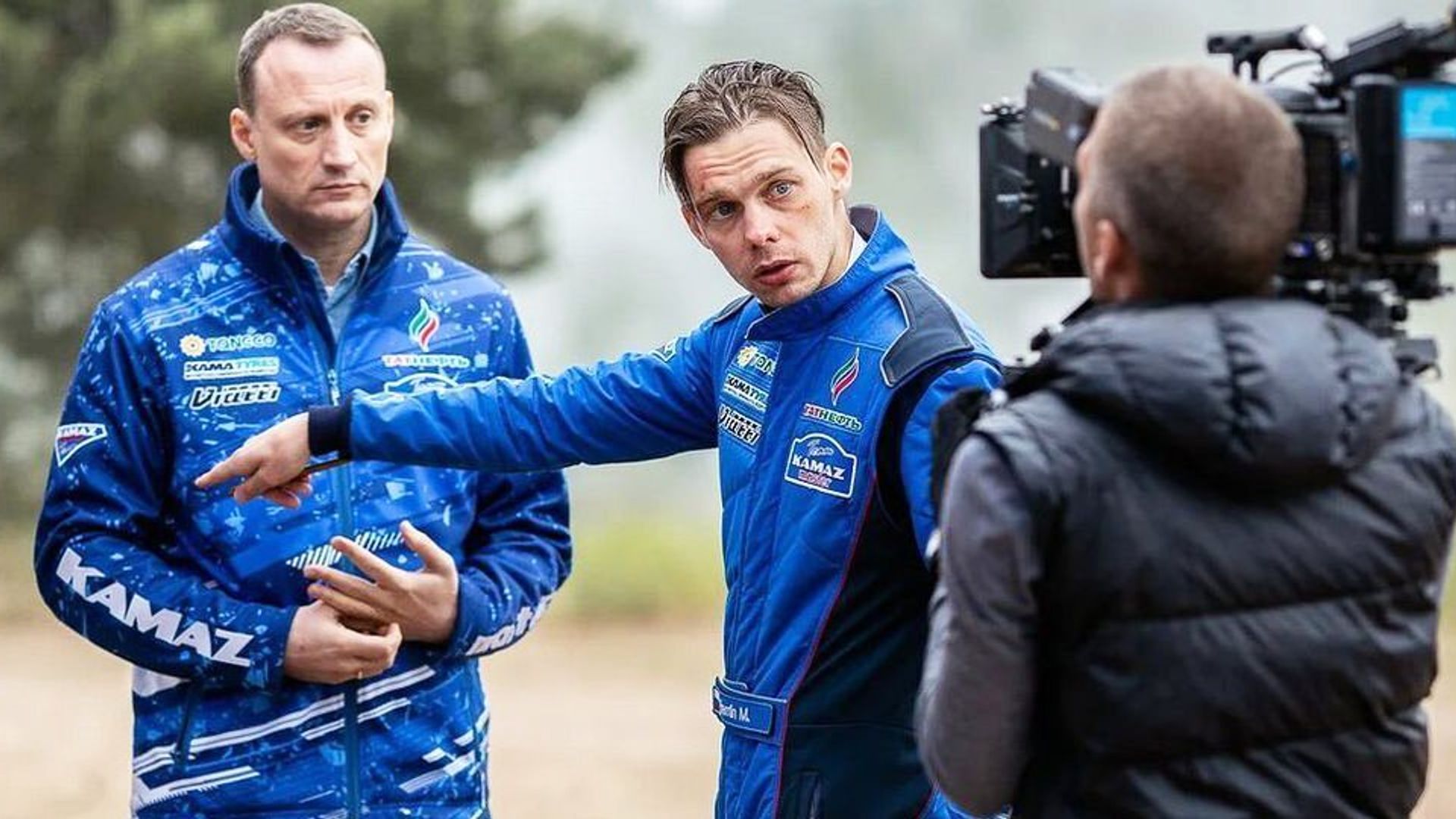 Аристарх Венес в синем комбинезоне, его снимают на камеру