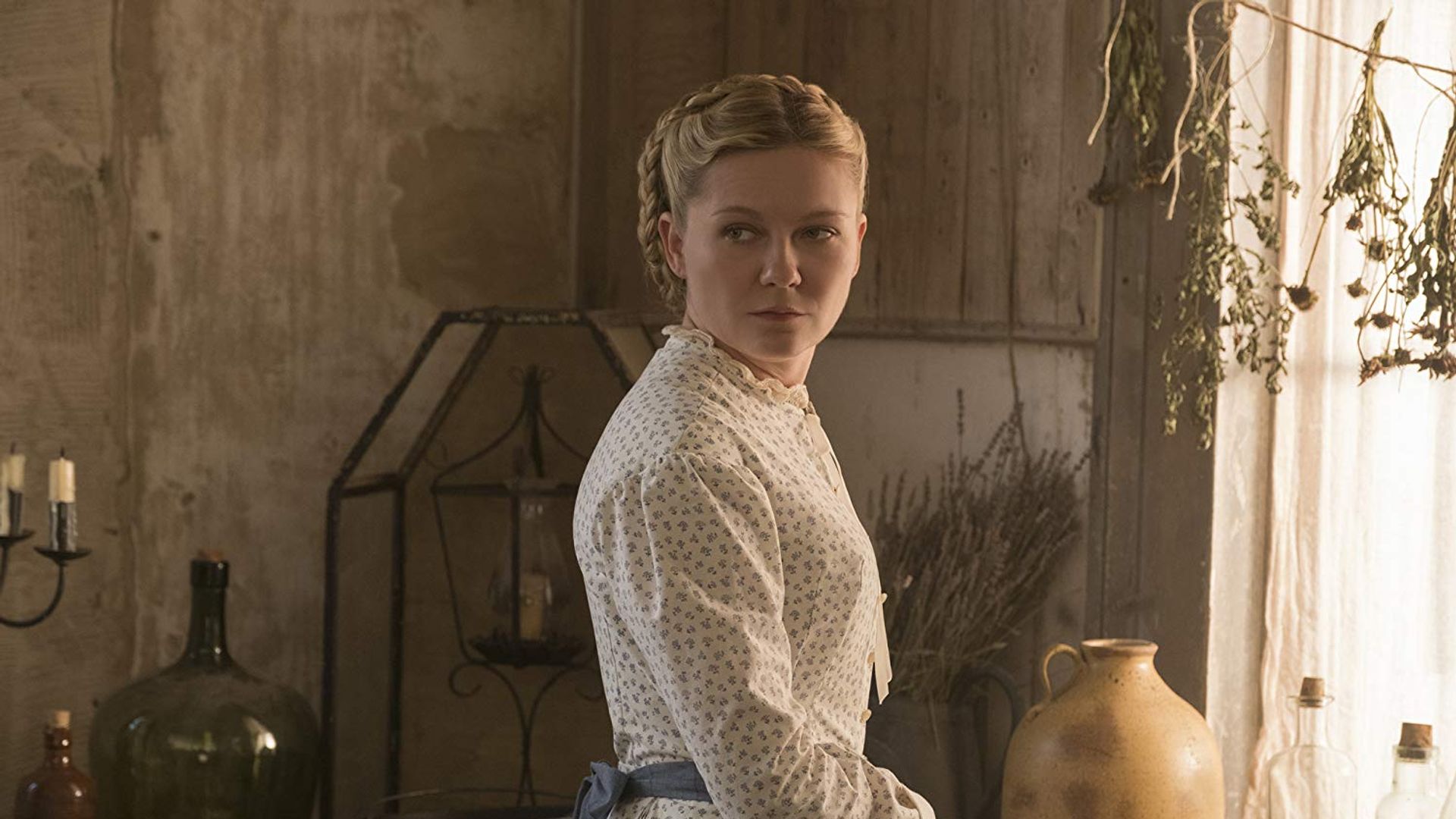 Кирстен Данст в винтажном белом платье стоит в полоборота