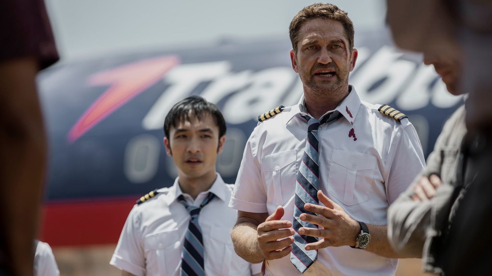 Джерард Батлер в форме пилота на фоне самолёта, кадр из фильма