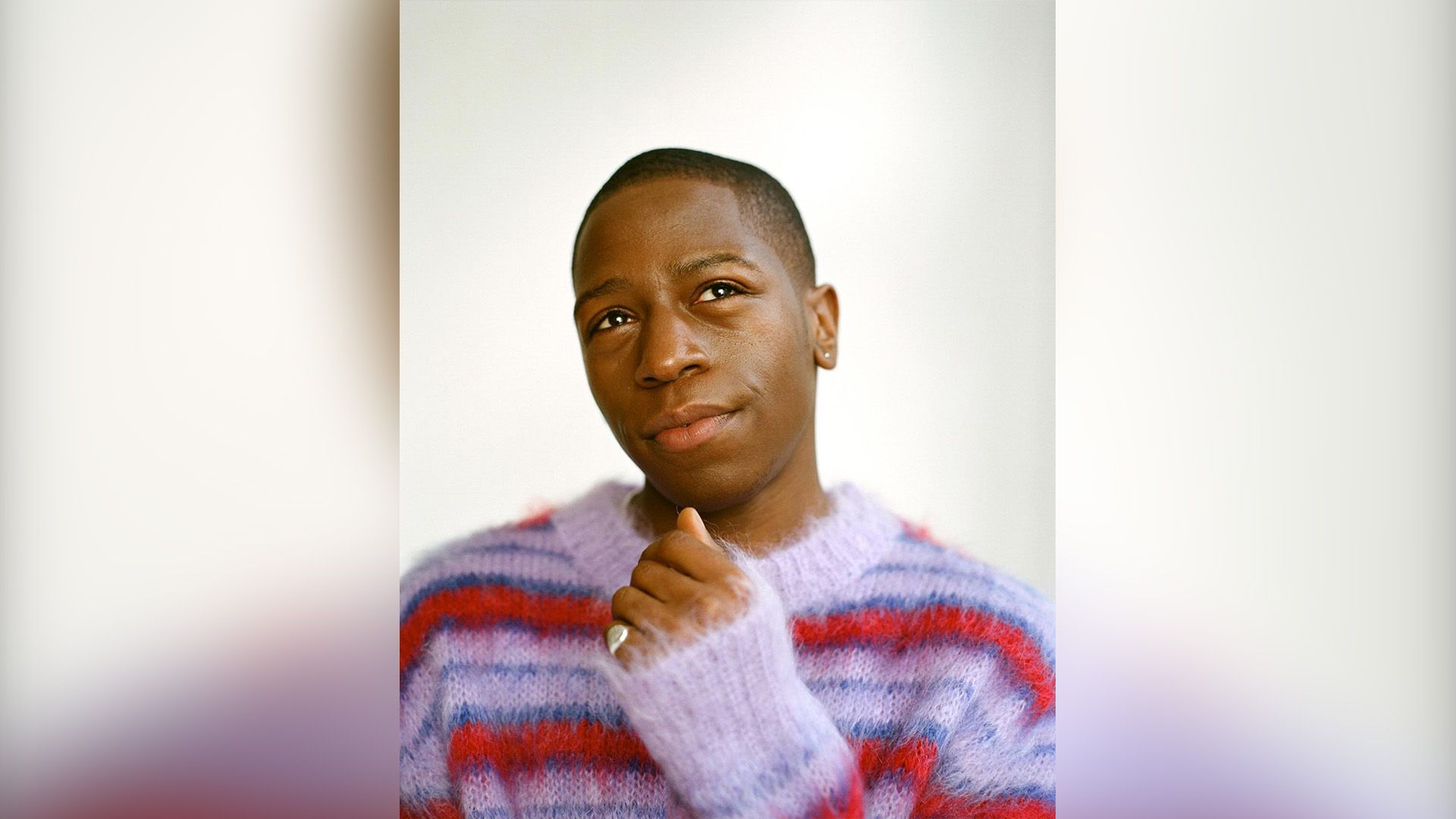 Дэвид Джонссон в пушистом свитере в красно-сиреневую полоску мечтательно смотрит вверх