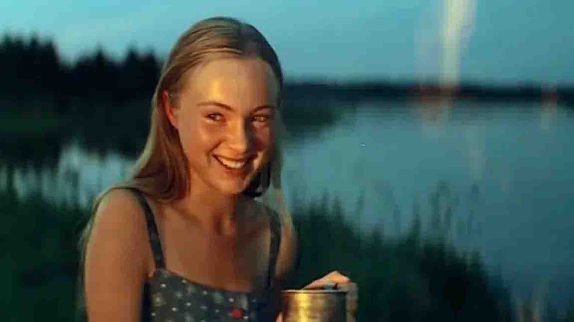 Марина Яковлева на берегу реки вечером широко улыбается