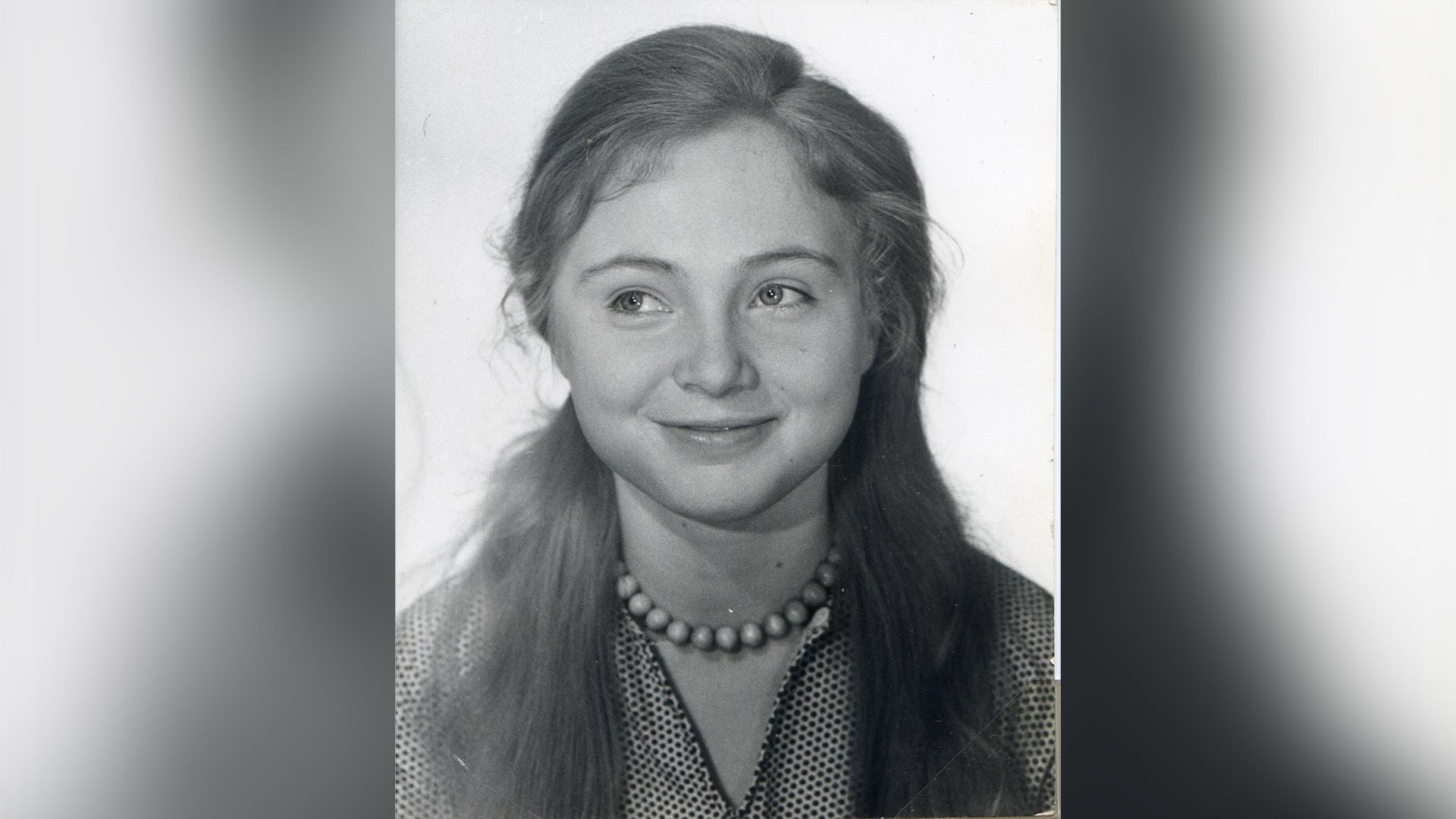 Юная Марина Яковлева с крупными бусами на шее улыбается и смотрит в сторону