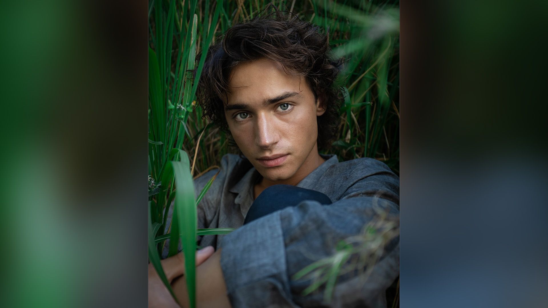 Актёр Андрей Мартынов сидит в высокой траве