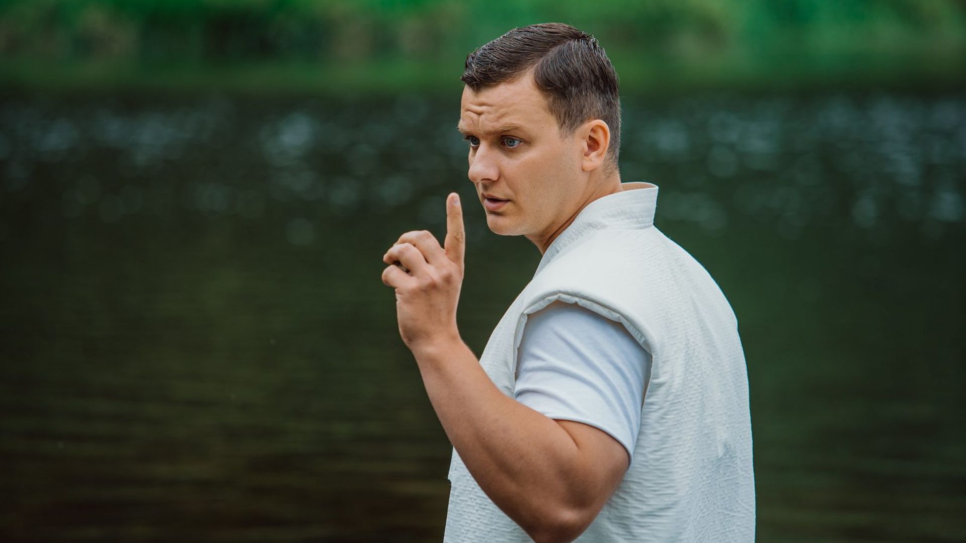 Филипп Бледный в белой одежде на фоне зелени и водоёма