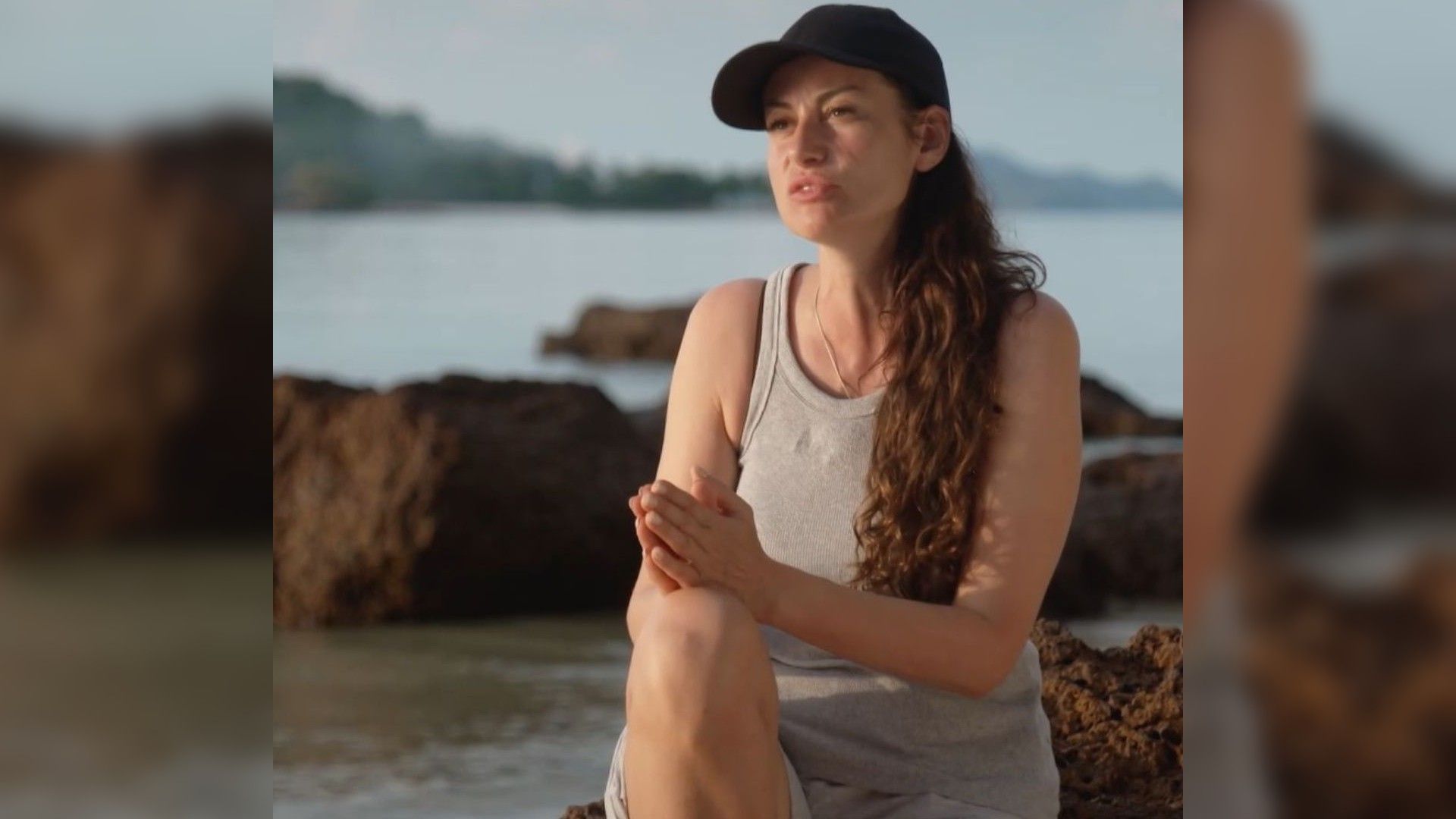 Анна Ковальчук в майке и кепке на фоне моря