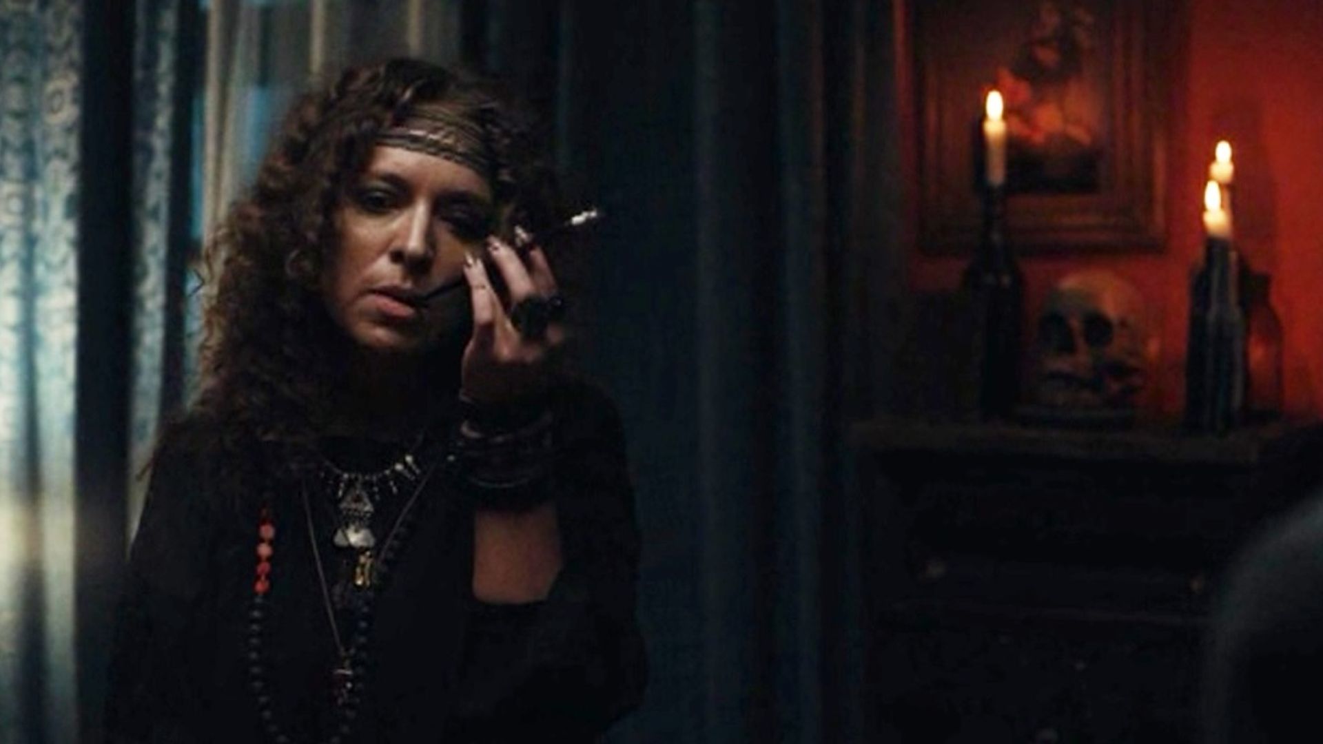 Серафима Низовская в одежде хиппи в тёмной комнате