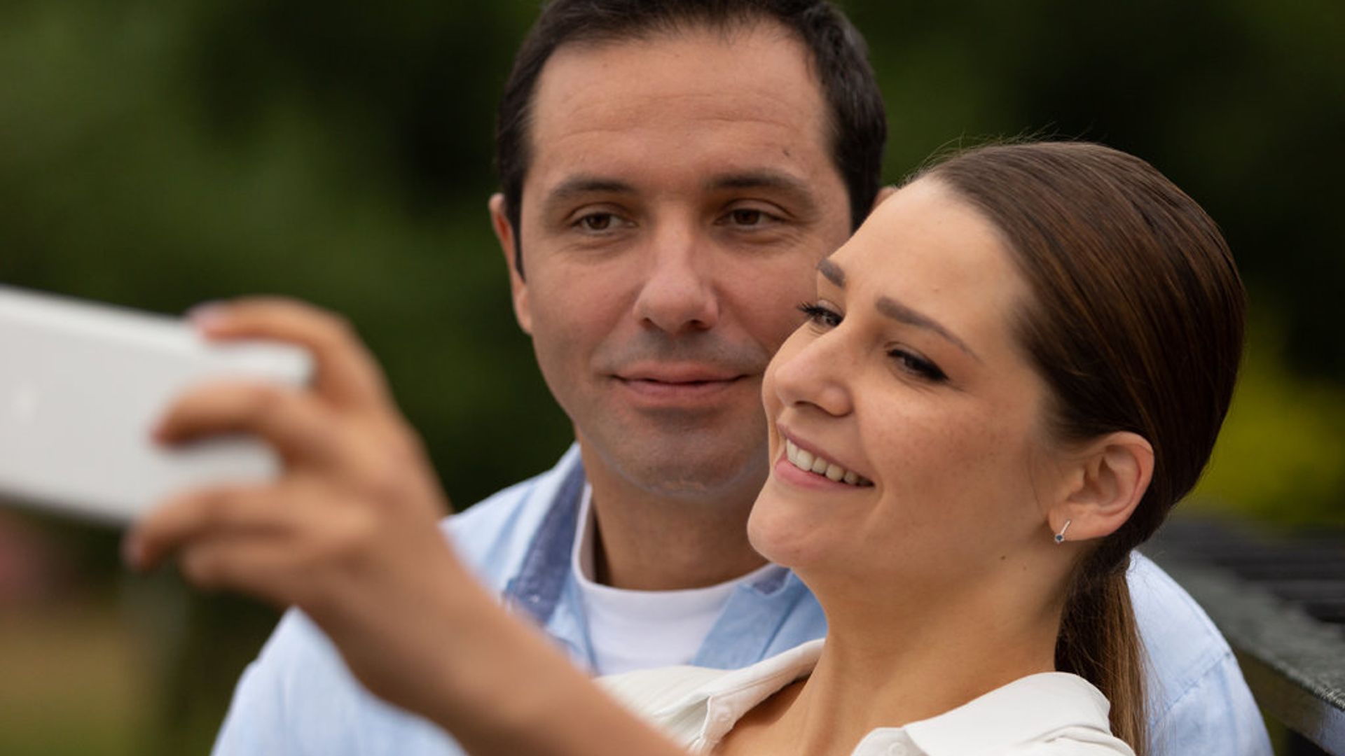 Женщина снимает себя с мужчиной на телефон