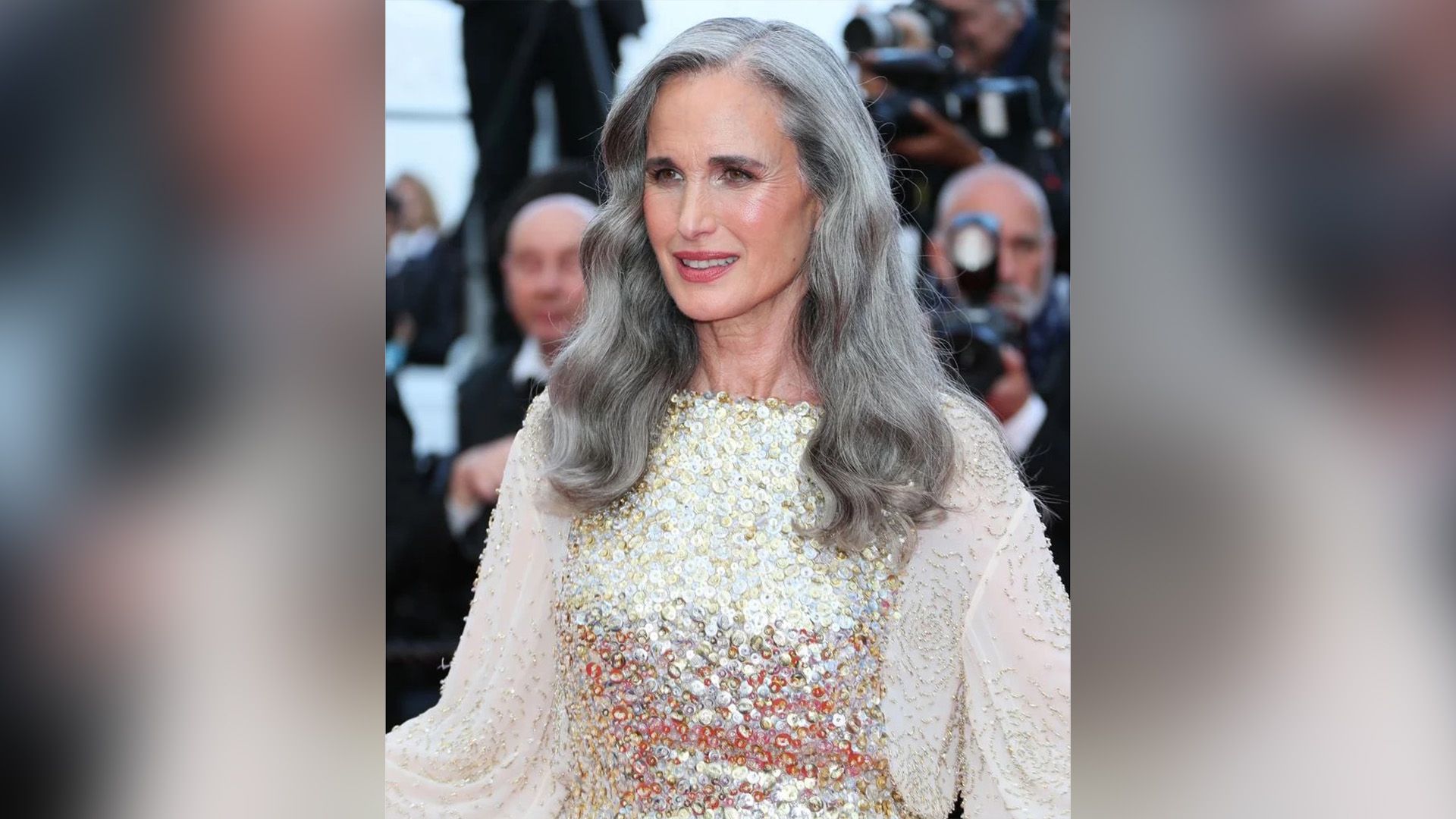 Энди МакДауэлл с длинными седыми волосами, одетая в белое платье с блёстками