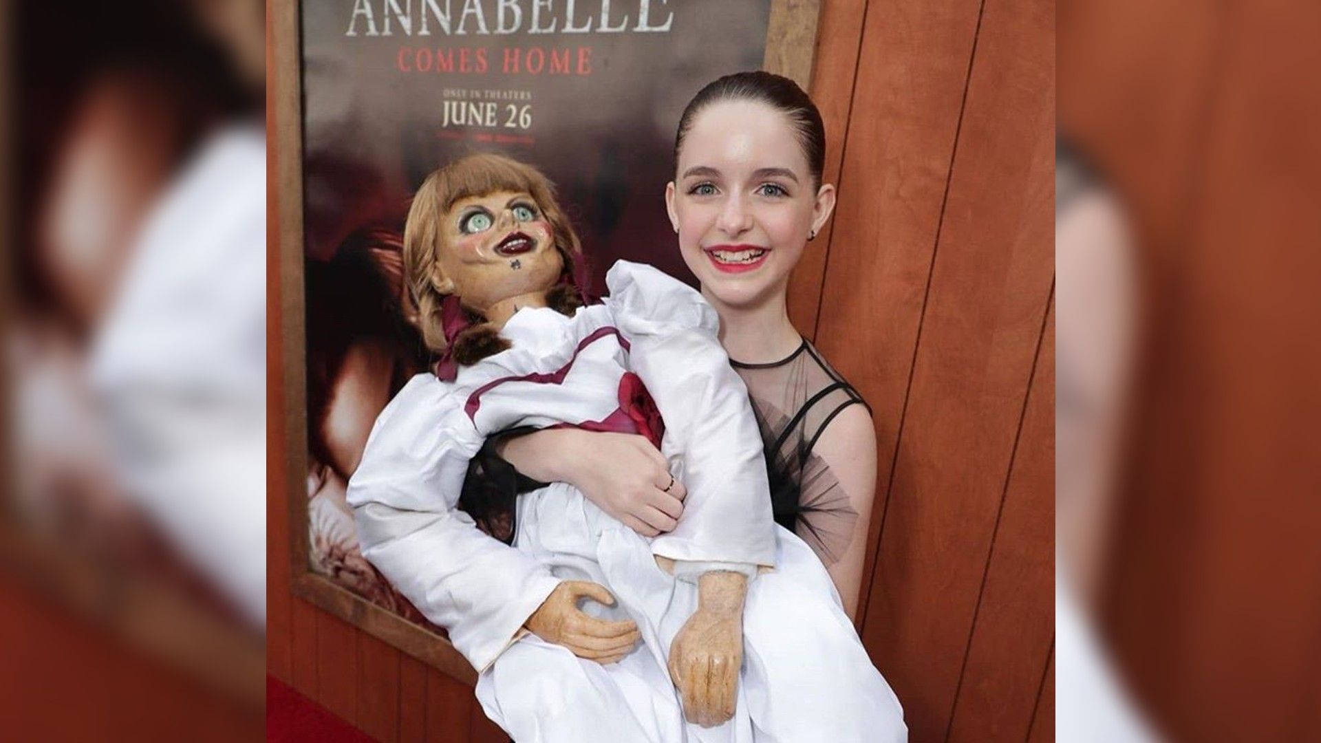 Маккена Грейс держит на руках страшную куклу и улыбается