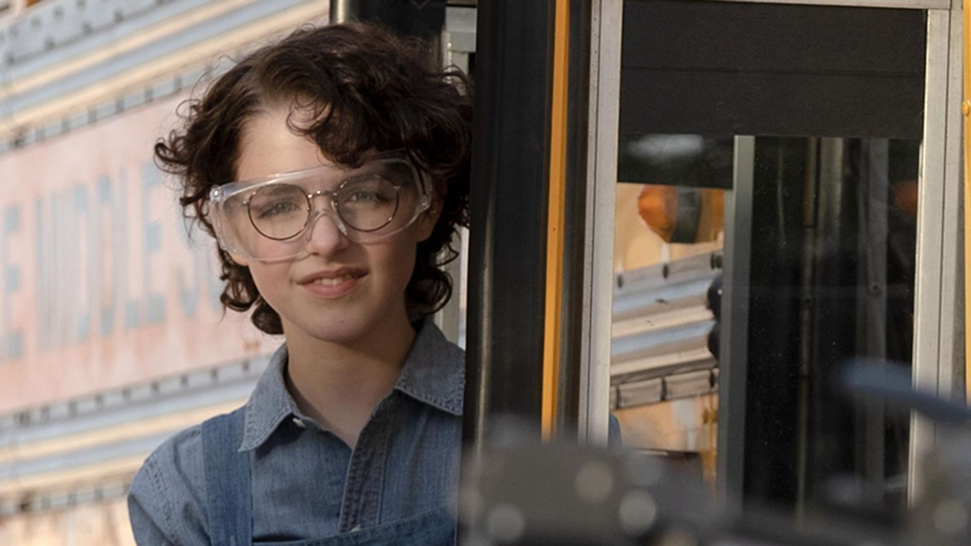 Маккена Грейс с короткими чёрными кудряшками и в очках, кадр из фильма