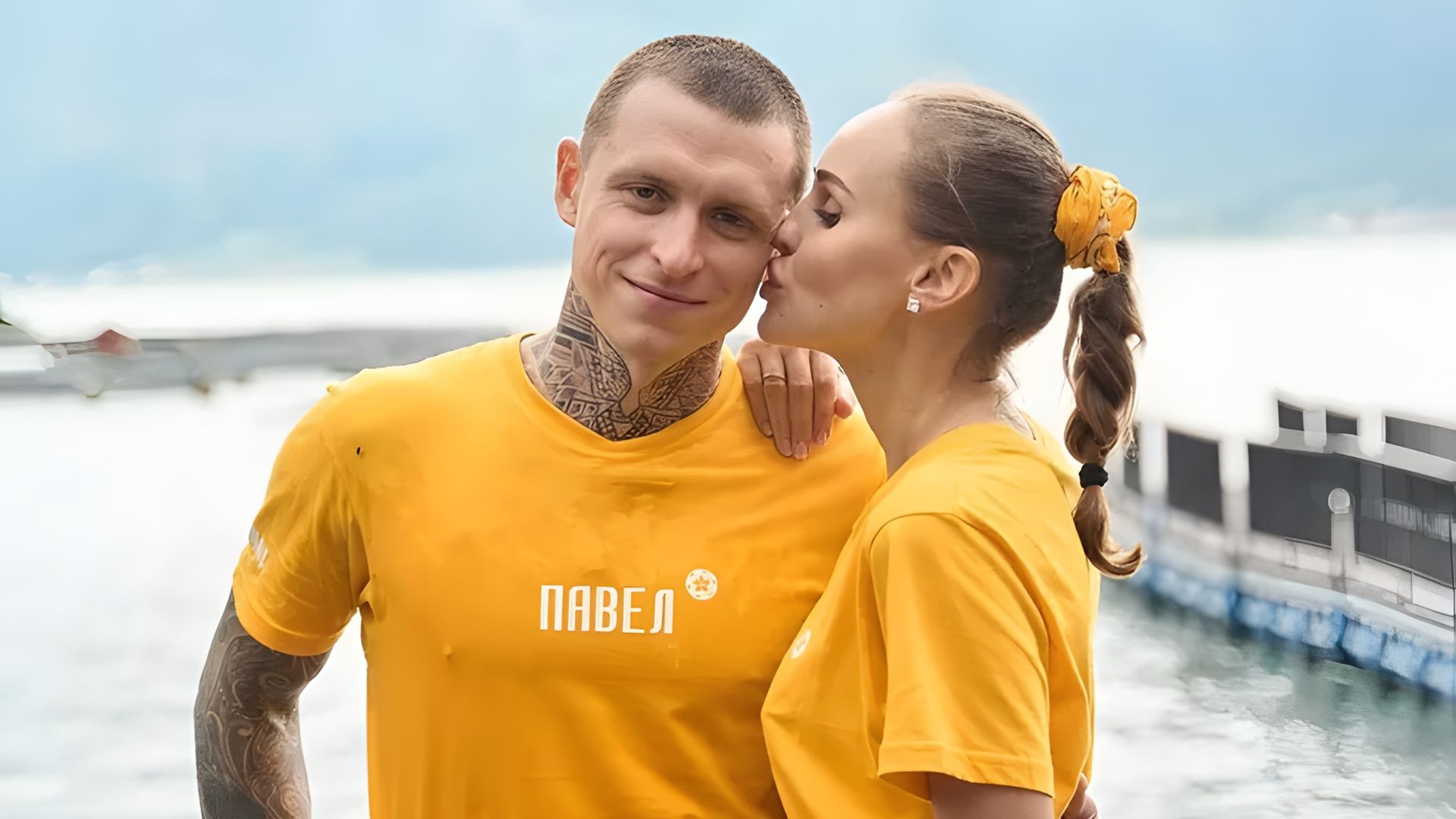 Надежда Мамаева целует Павла Мамаева в щёку, оба в жёлтых футболках