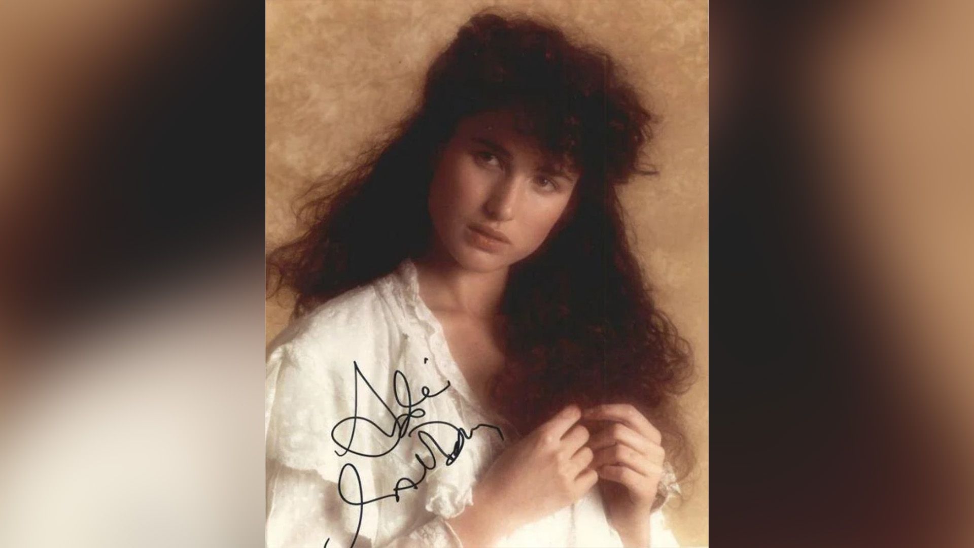 Юная Энди МакДауэлл с пышной кудрявой причёской, одетая в белую кружевную блузку