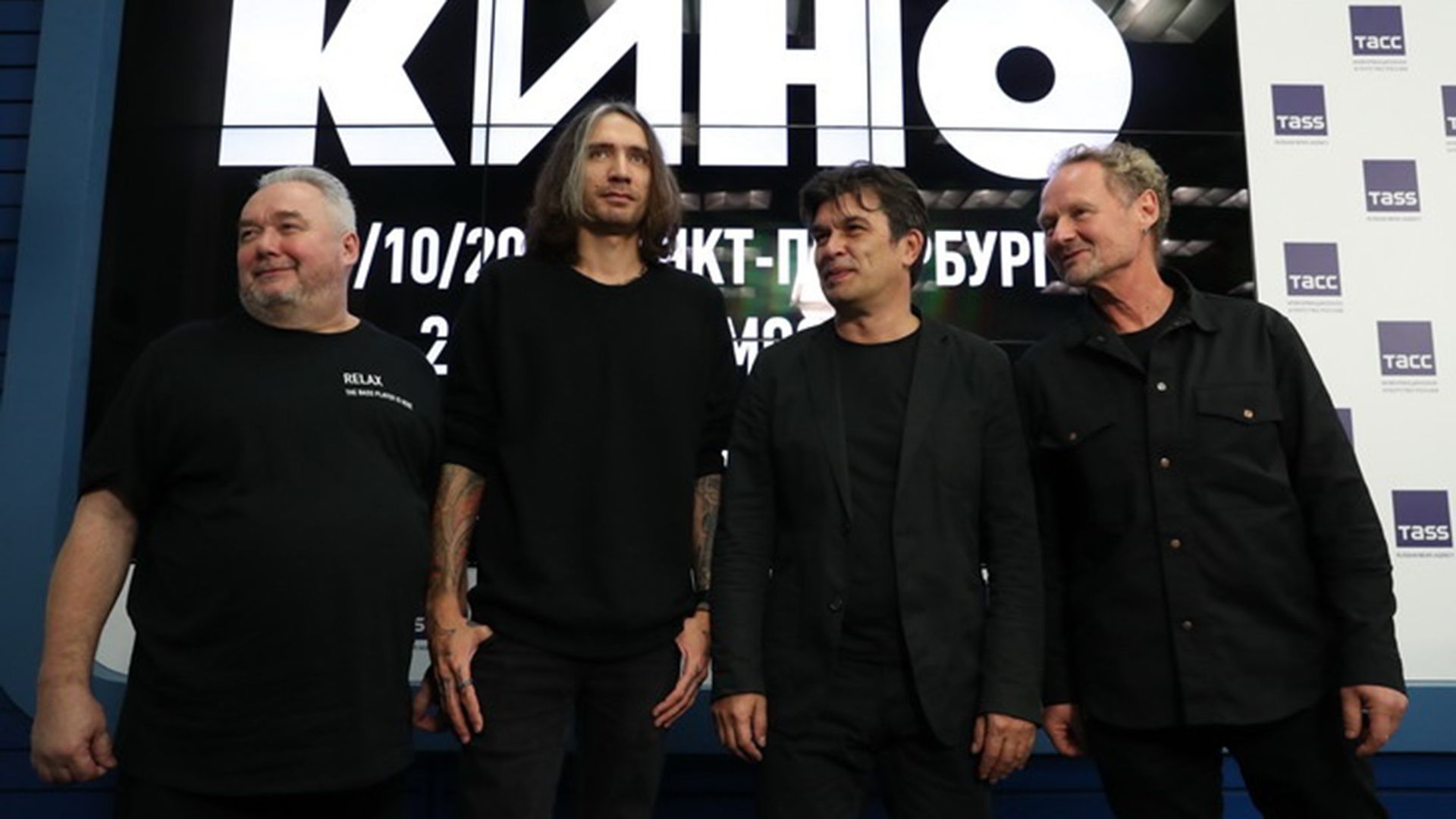 Александр Цой и музыканты группы "Кино" на фоне больших букв Кино