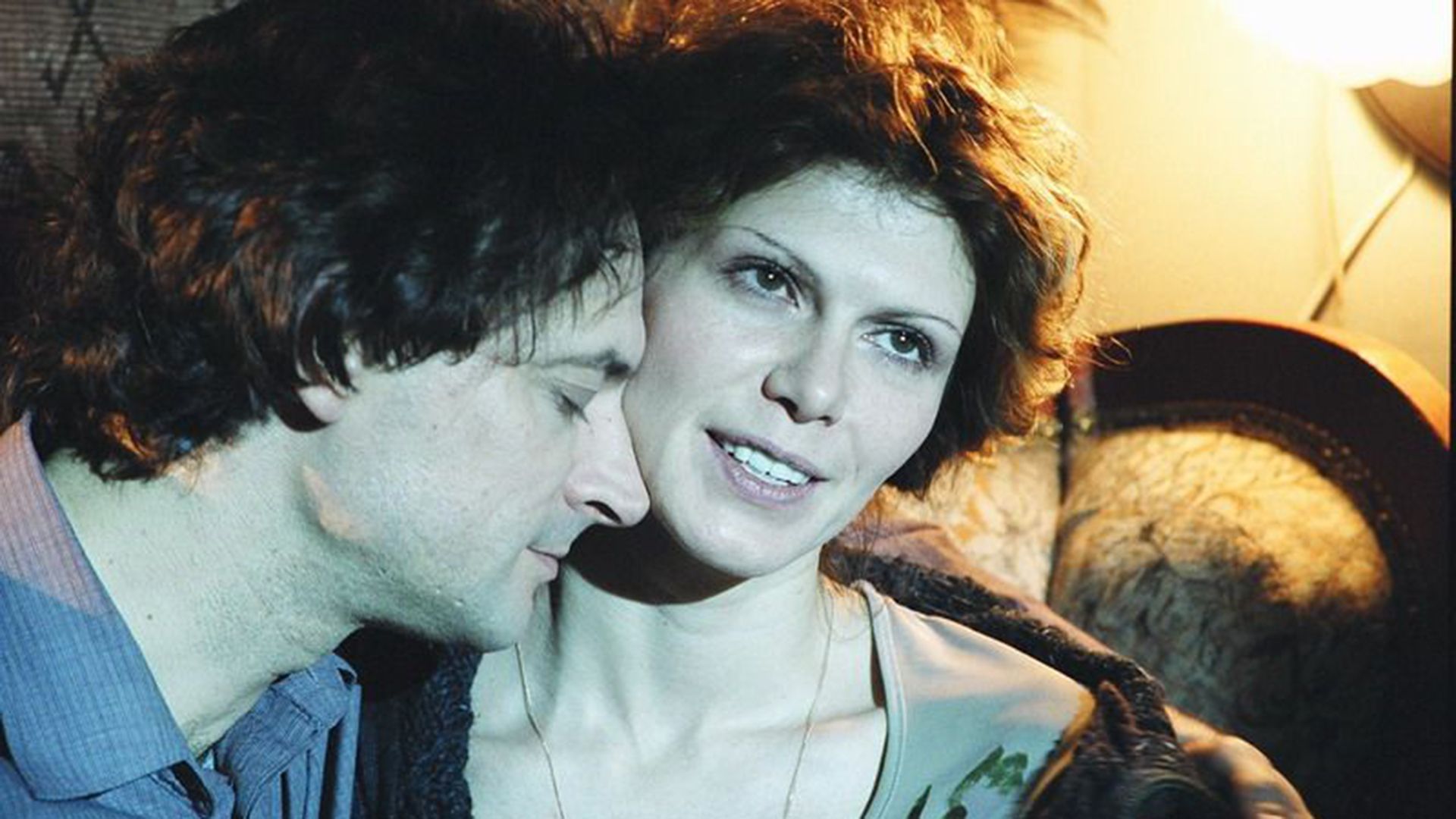 Регина Мянник с улыбкой смотрит вверх, к её лицу прижимается мужчина