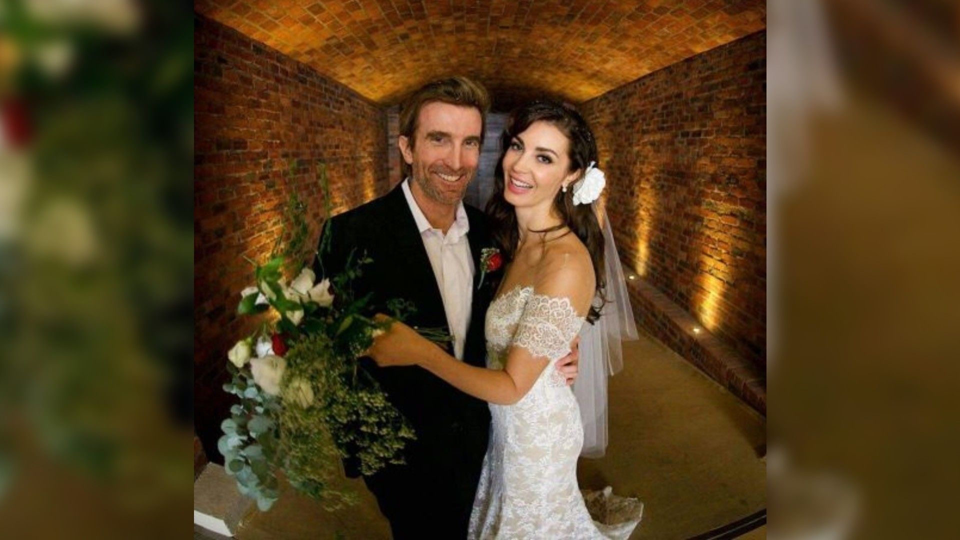 Шарлто Копли и Танит Феникс в свадебных нарядах улыбаются на камеру