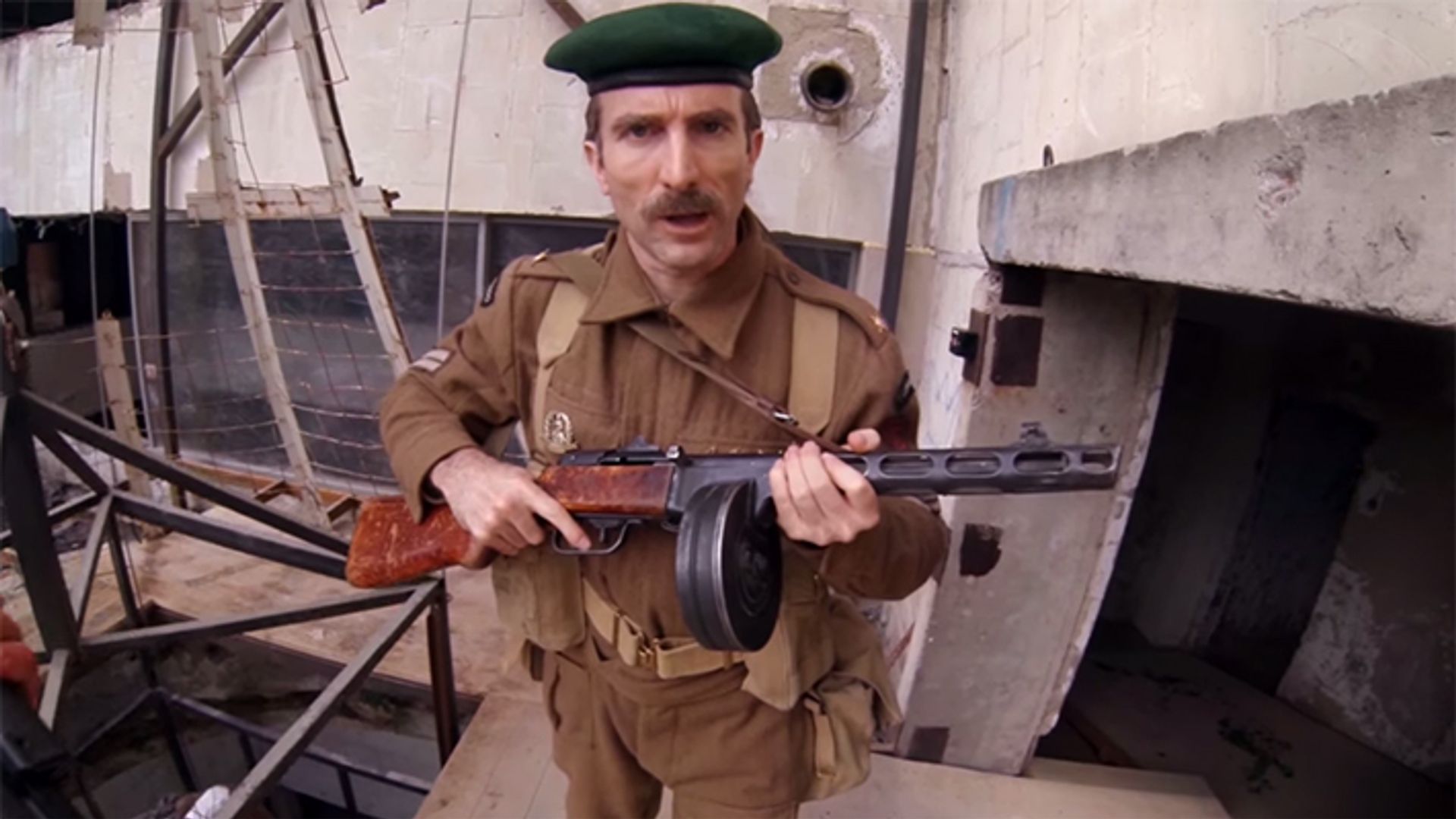 Шарлто Копли в военной форме с автоматом в руках