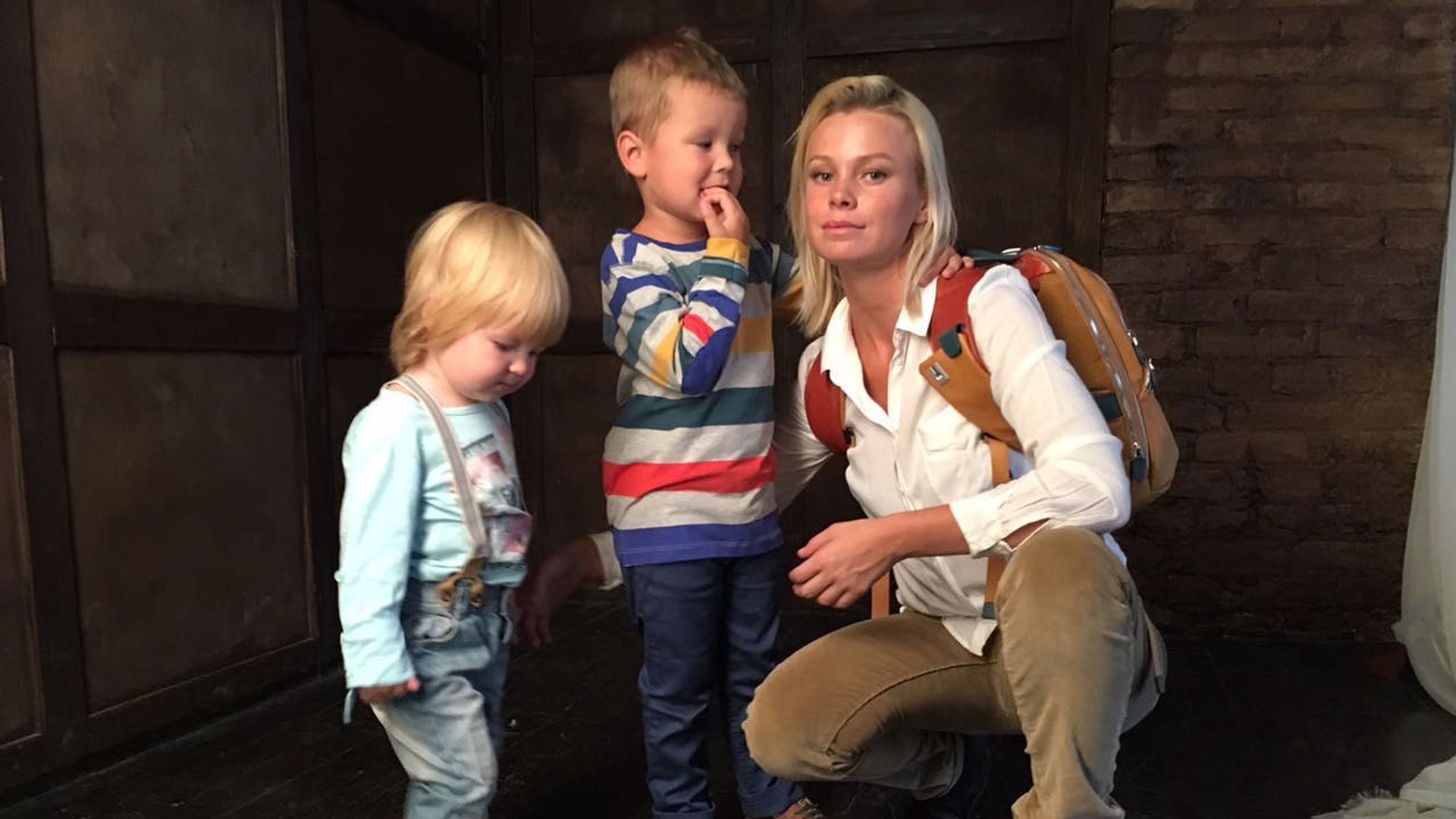 Евгения Осипова стоит рядом с мальчиком и девочкой