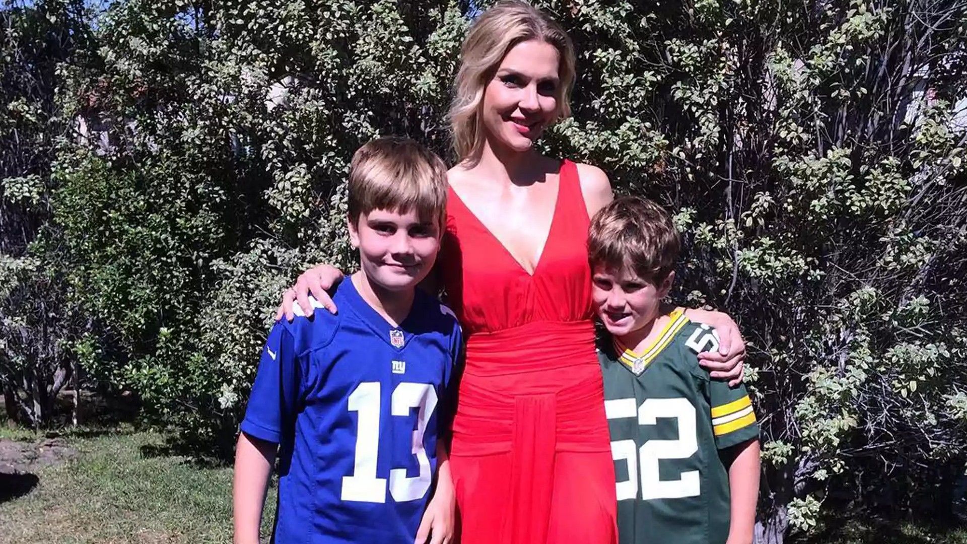 Рэй Сихорн обнимает двух мальчиков в футбольной форме