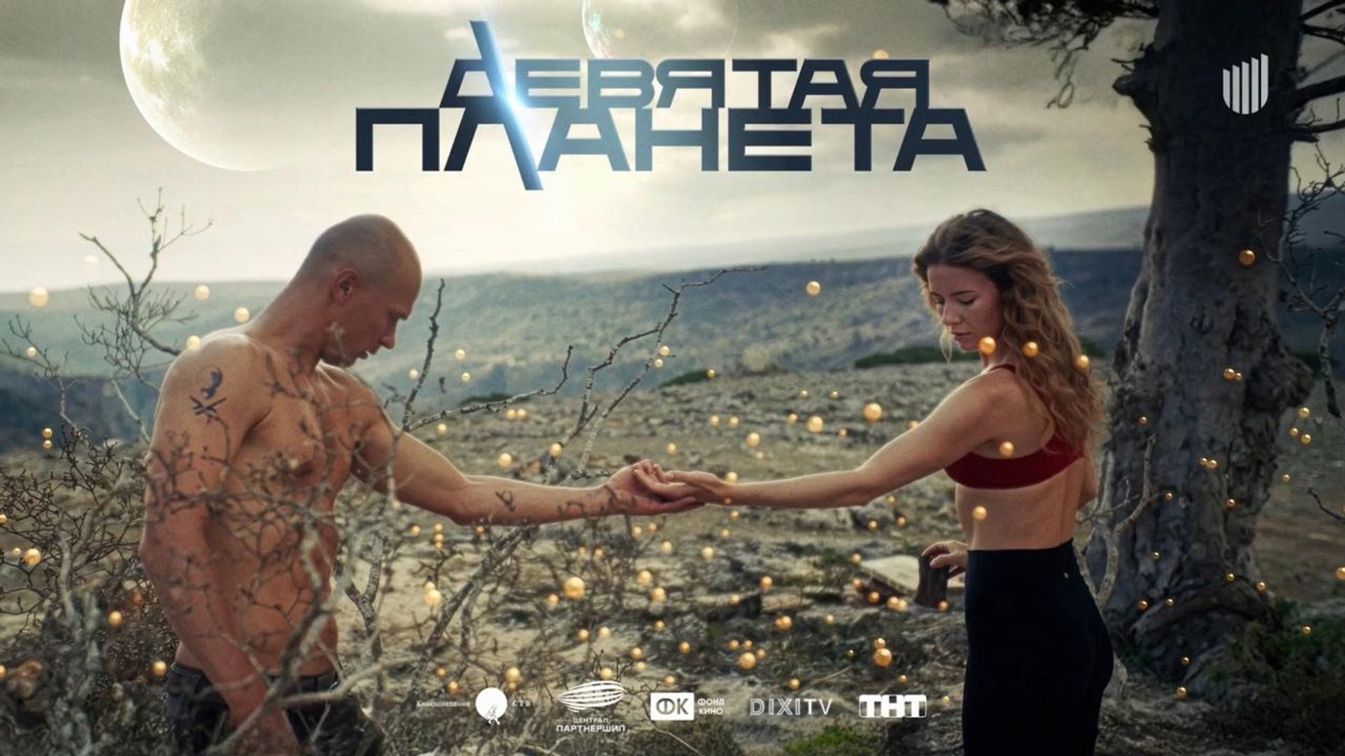 Актер Юра Борисов протягивает руку девушке на фоне огоньков и ветвей дерева