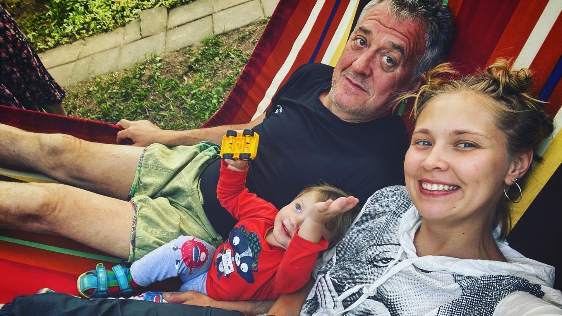 Виктория Романенко и Артур Ваха лежат в гамаке, между ними лежит ребёнок