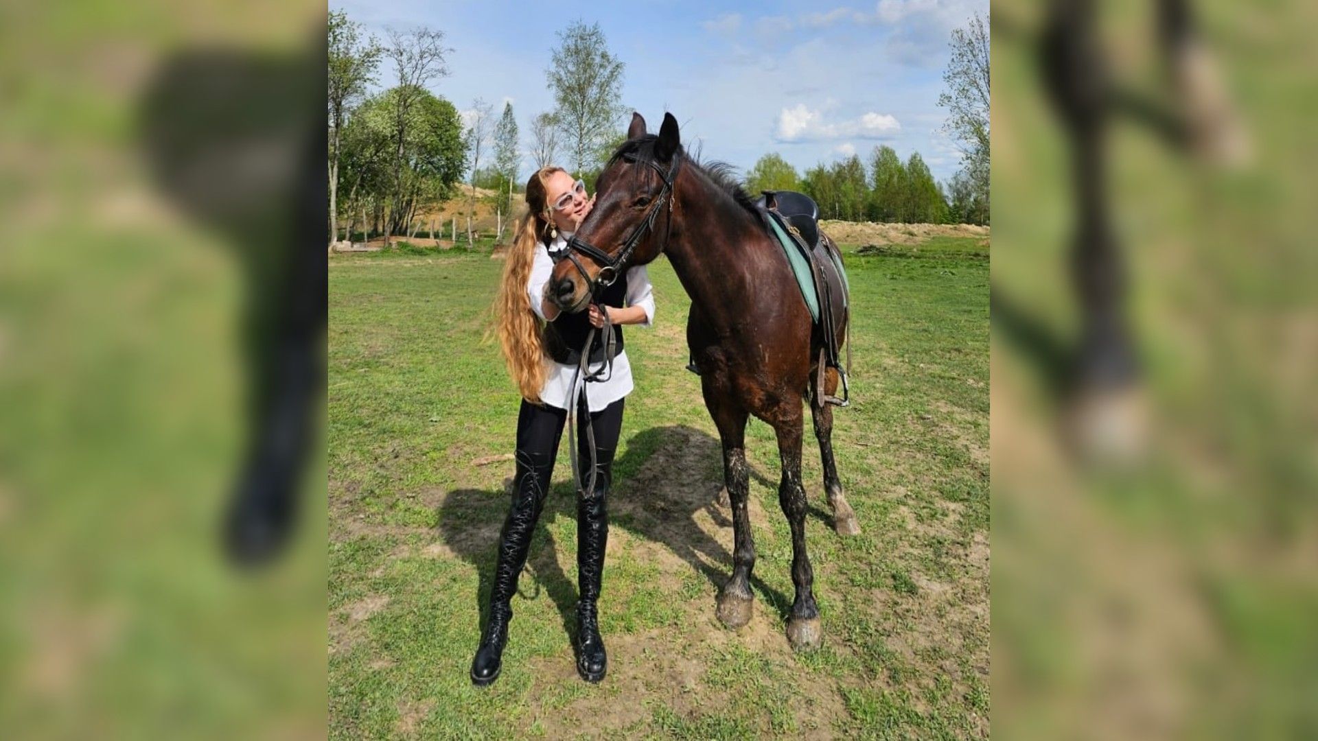 Анна Асти обнимает лошадь на фоне луга