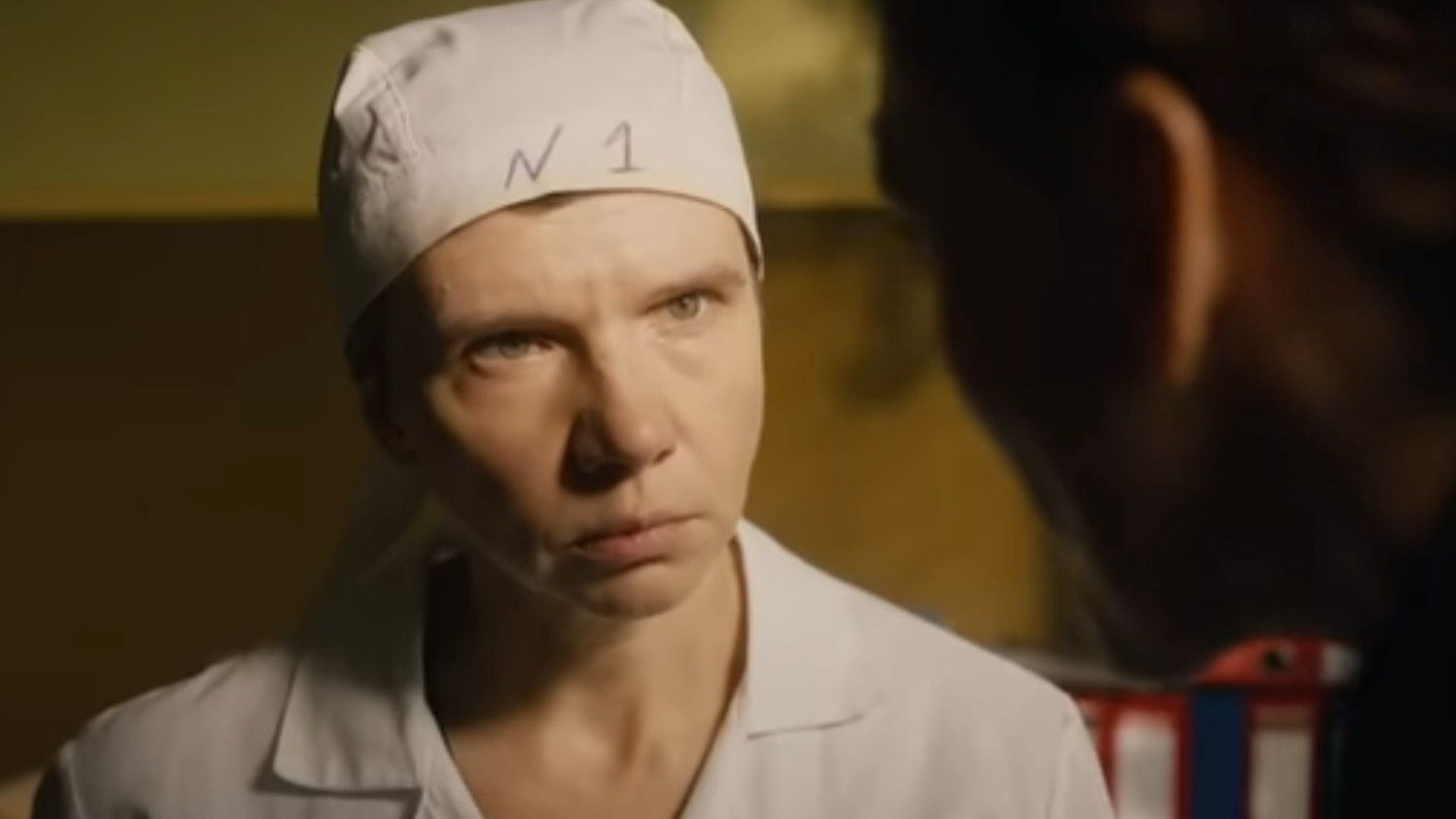 Ирина Рахманова в головной повязке смотрит исподлобья