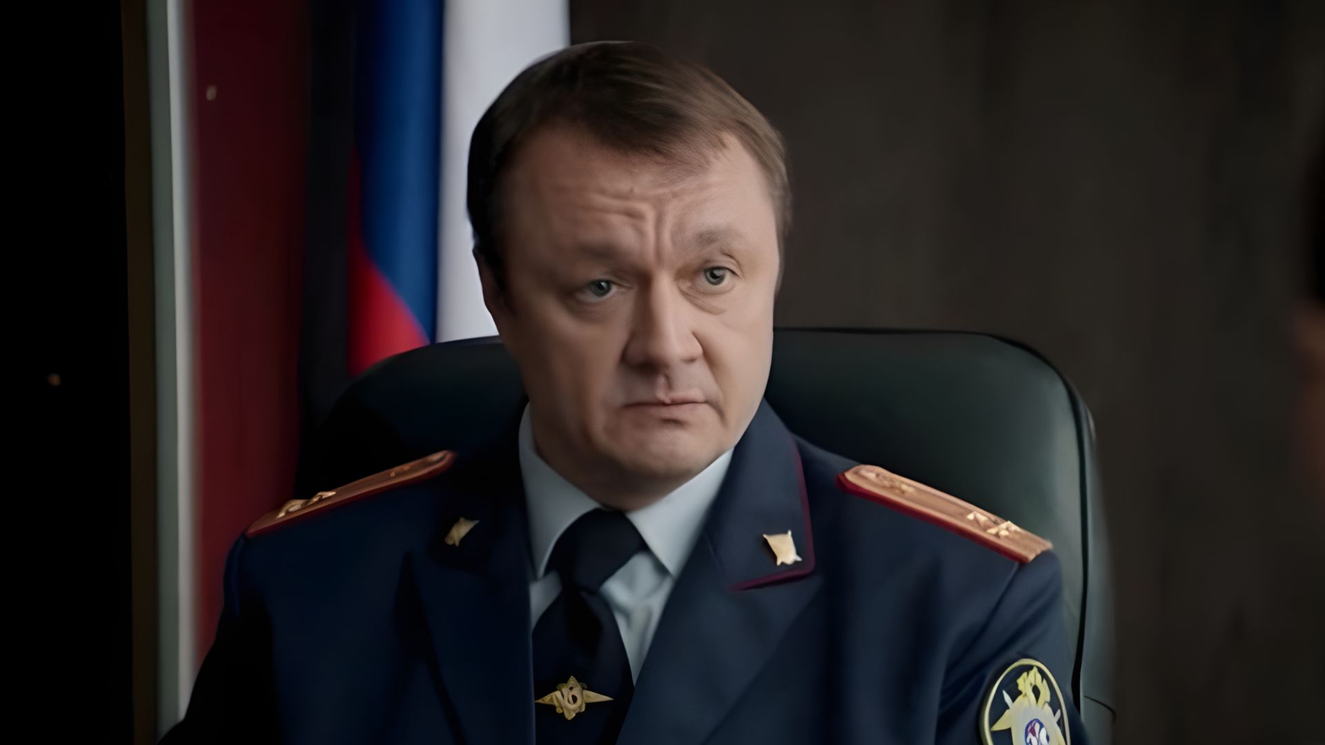 Владимир Шевельков в полицейской форме в кабинете смотрит вбок