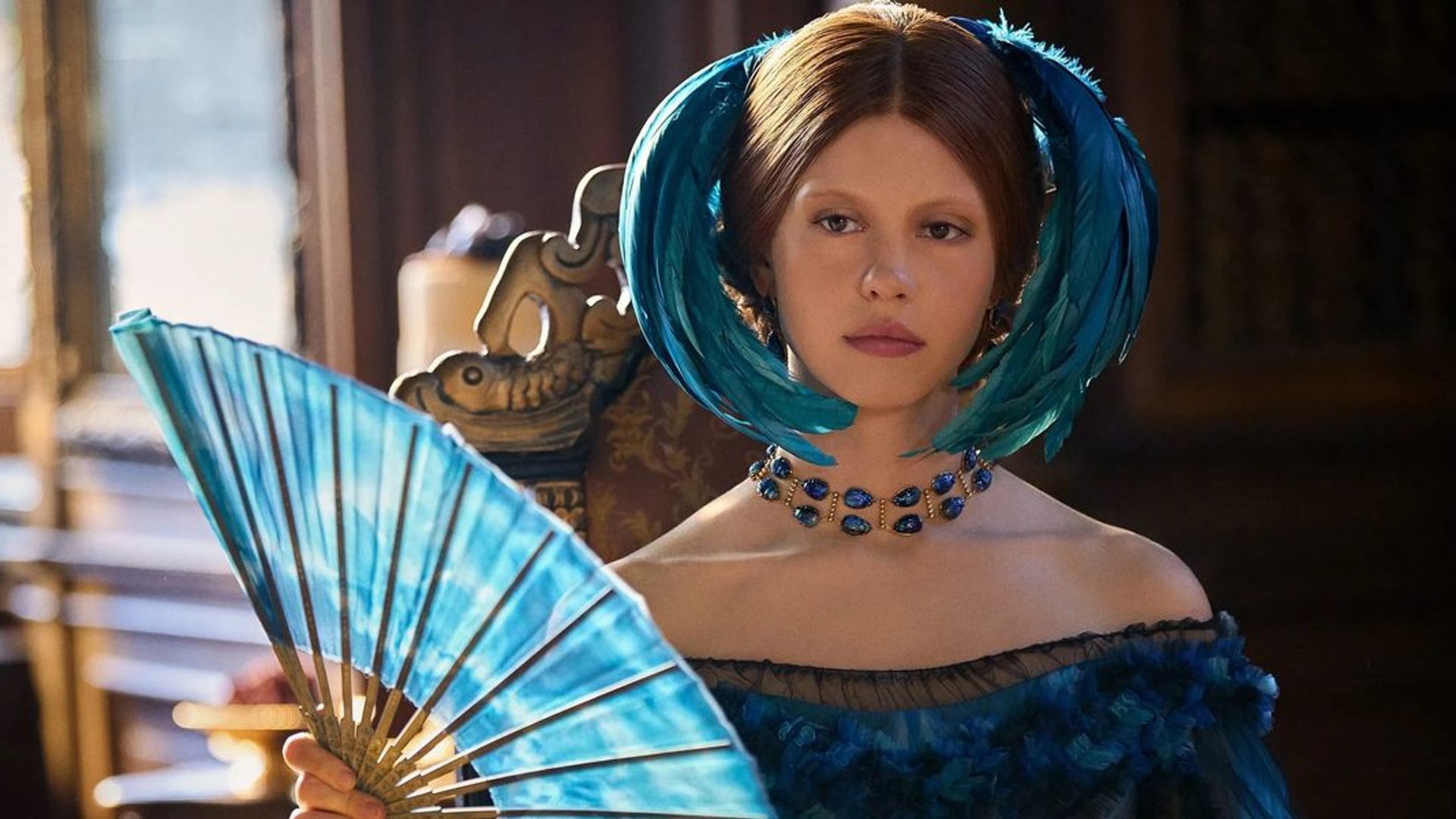 Миа Гот в бирюзовом платье викторианской эпохи с перьями в причёске и веером в руках