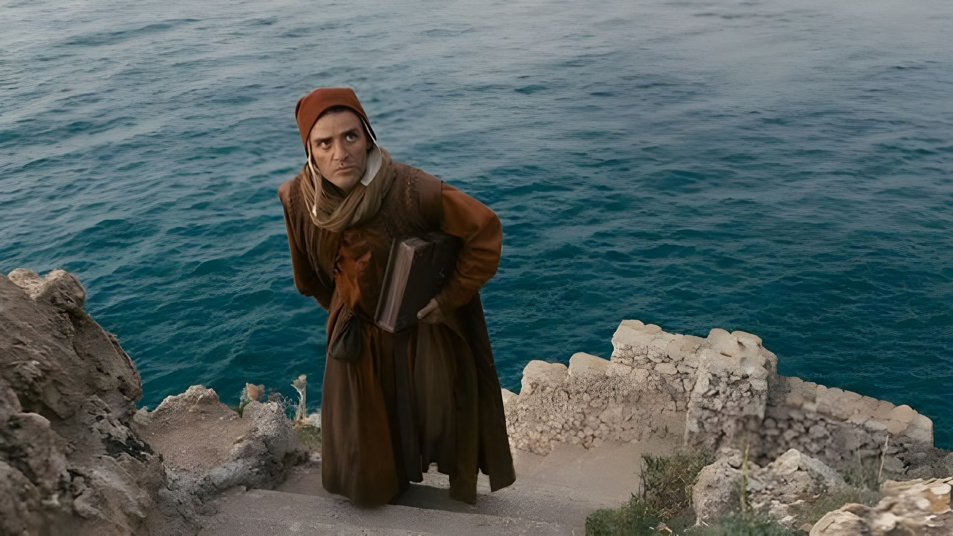 Оскар Айзек в средневековом наряде на фоне моря и скал