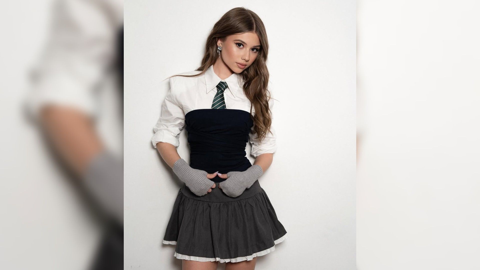 Милана Хаметова в школьной форме позирует на белом фоне