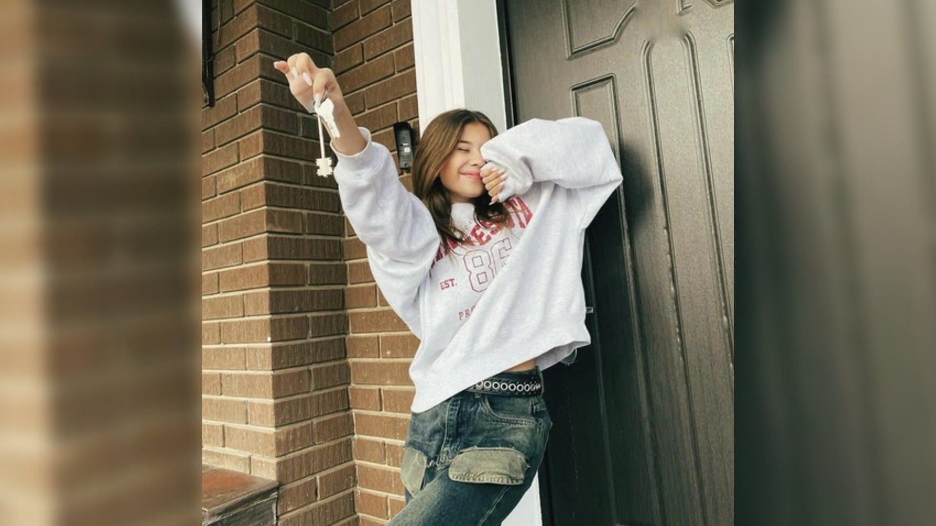 Милана Хаметова стоит на пороге дома, держа в руке связку ключей