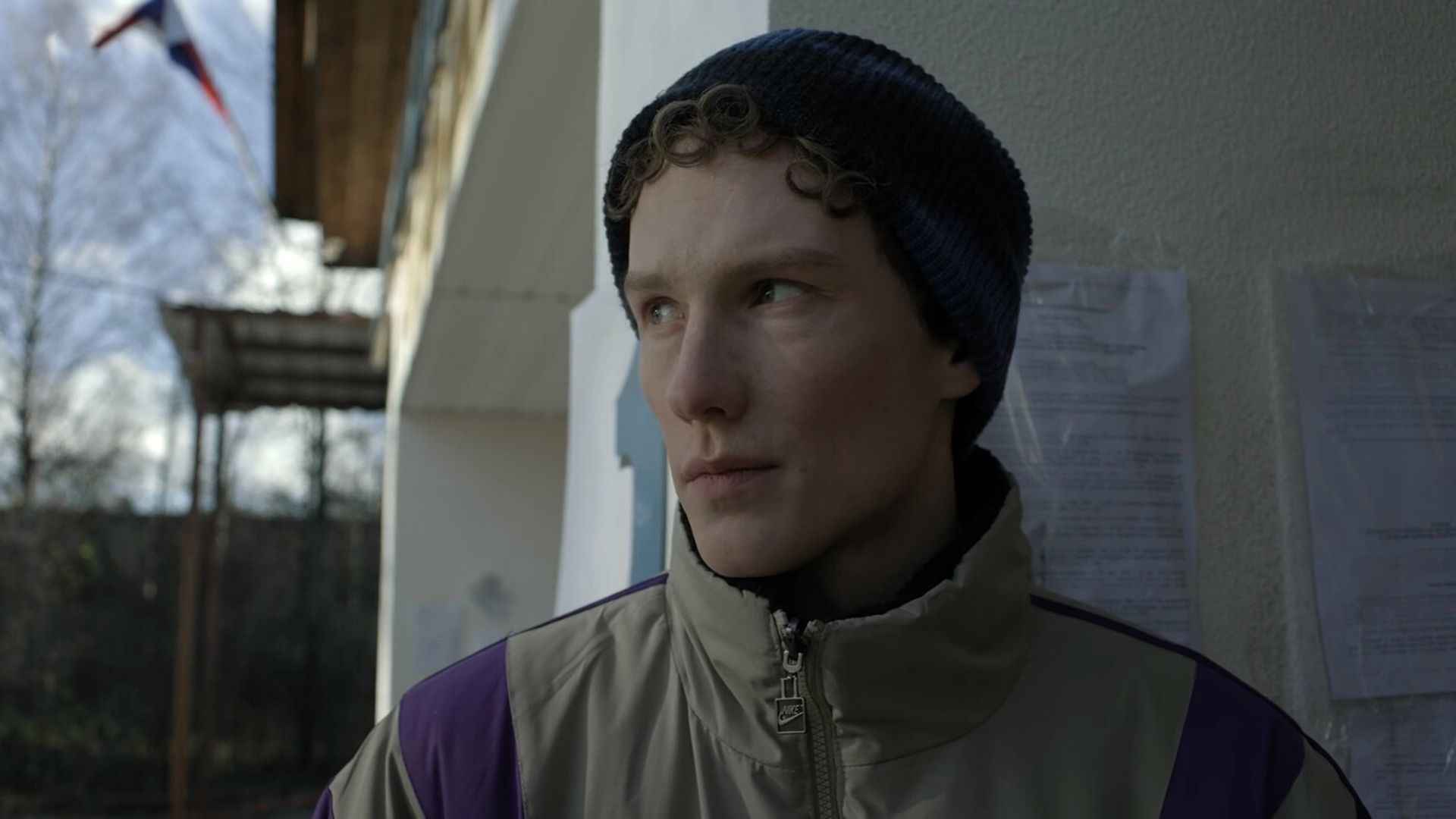 Илларион Маров в бежевой куртке и синей шапке смотрит в сторону