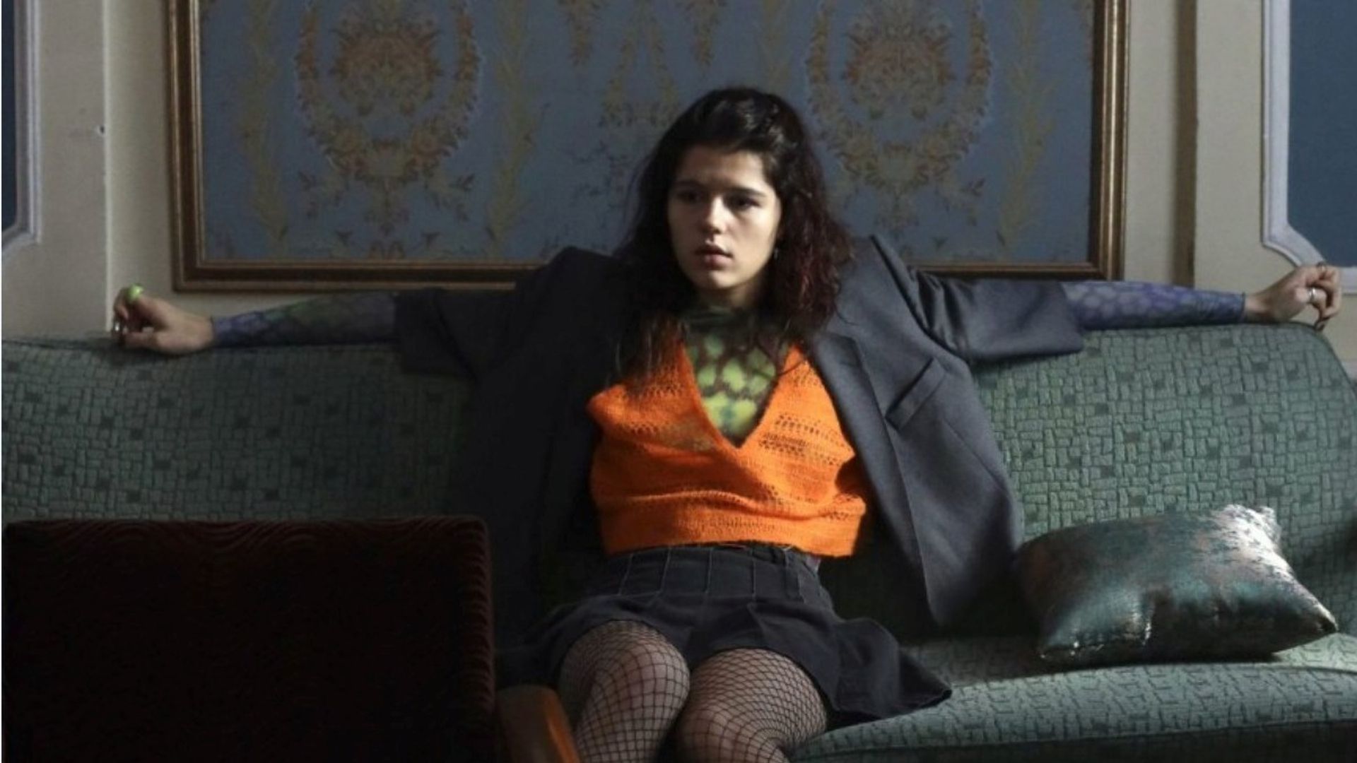 Мария Мацель в неформальной одежде сидит на диване