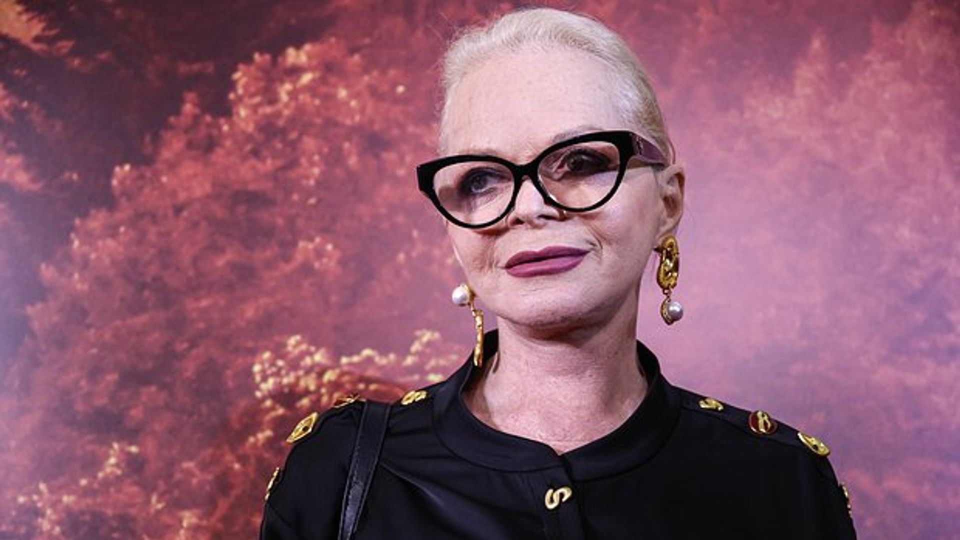 Лариса Долина в очках, черной кофте и больших золотистых серьгах с жемчугом