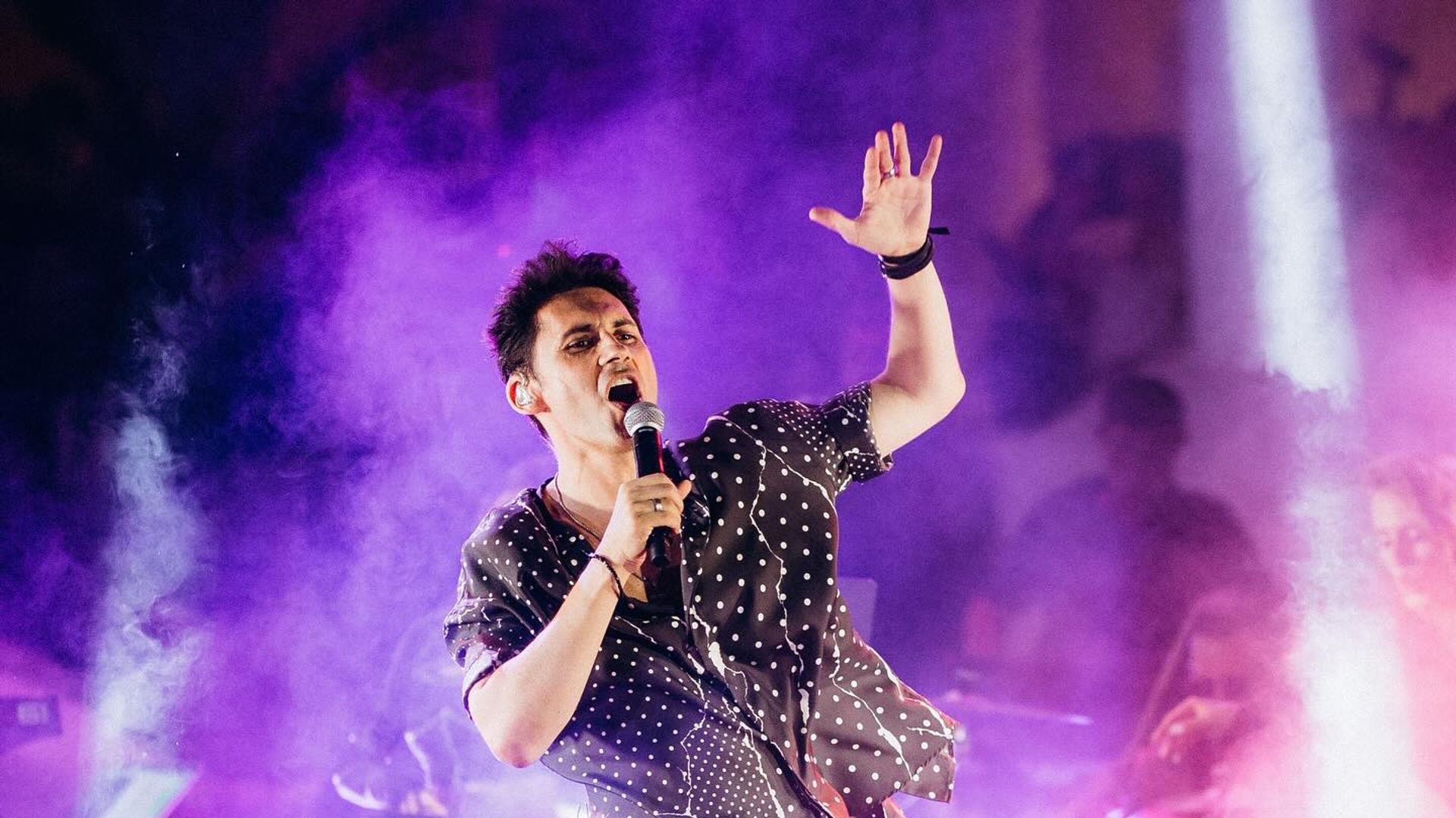 Дан Балан выступает на сцене, фиолетовый фон