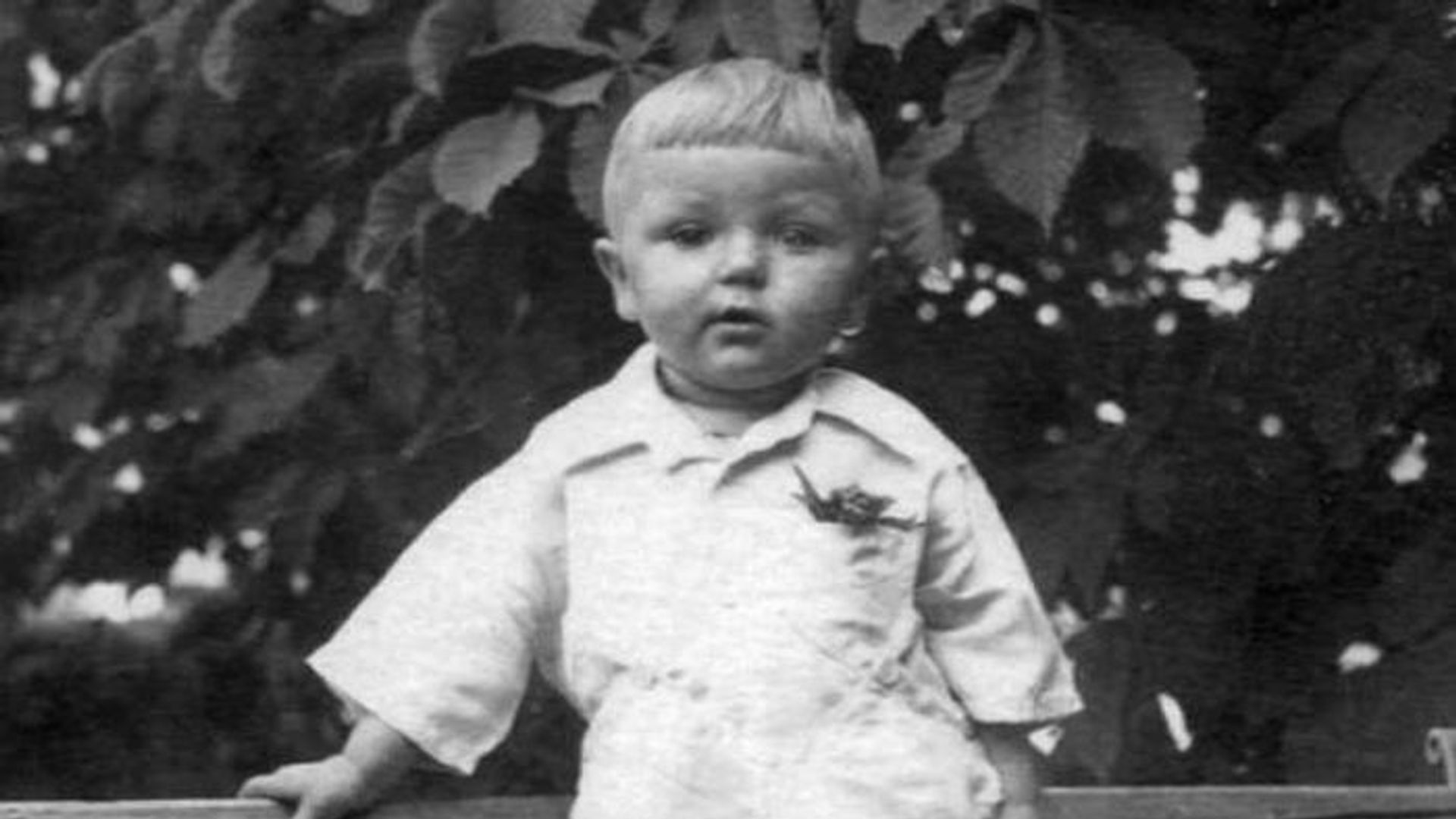 Маленький Юрий Николаев стоит на улице, черно-белое фото