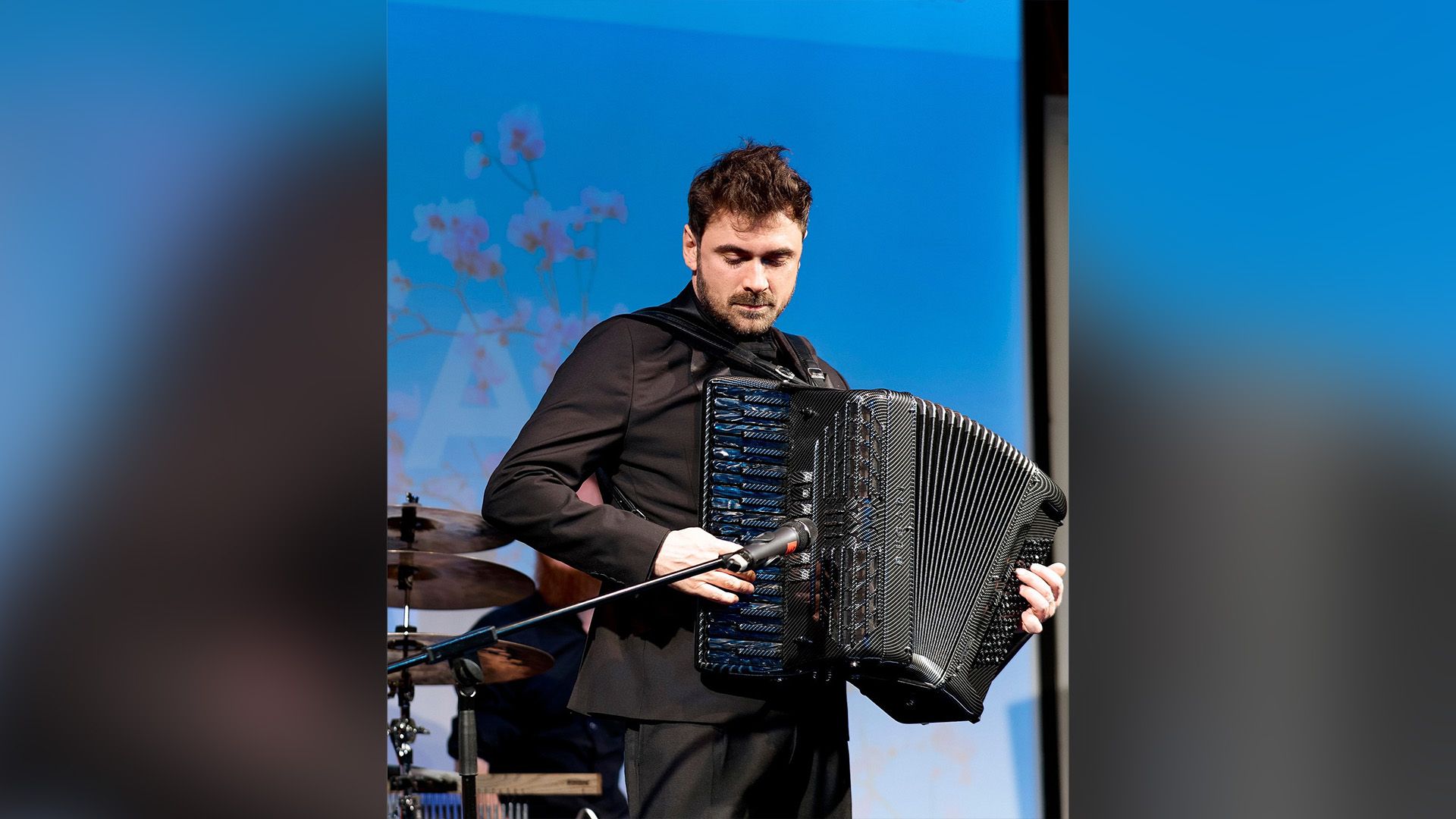 Петр Дранга в чёрном пиджаке играет на аккордеоне