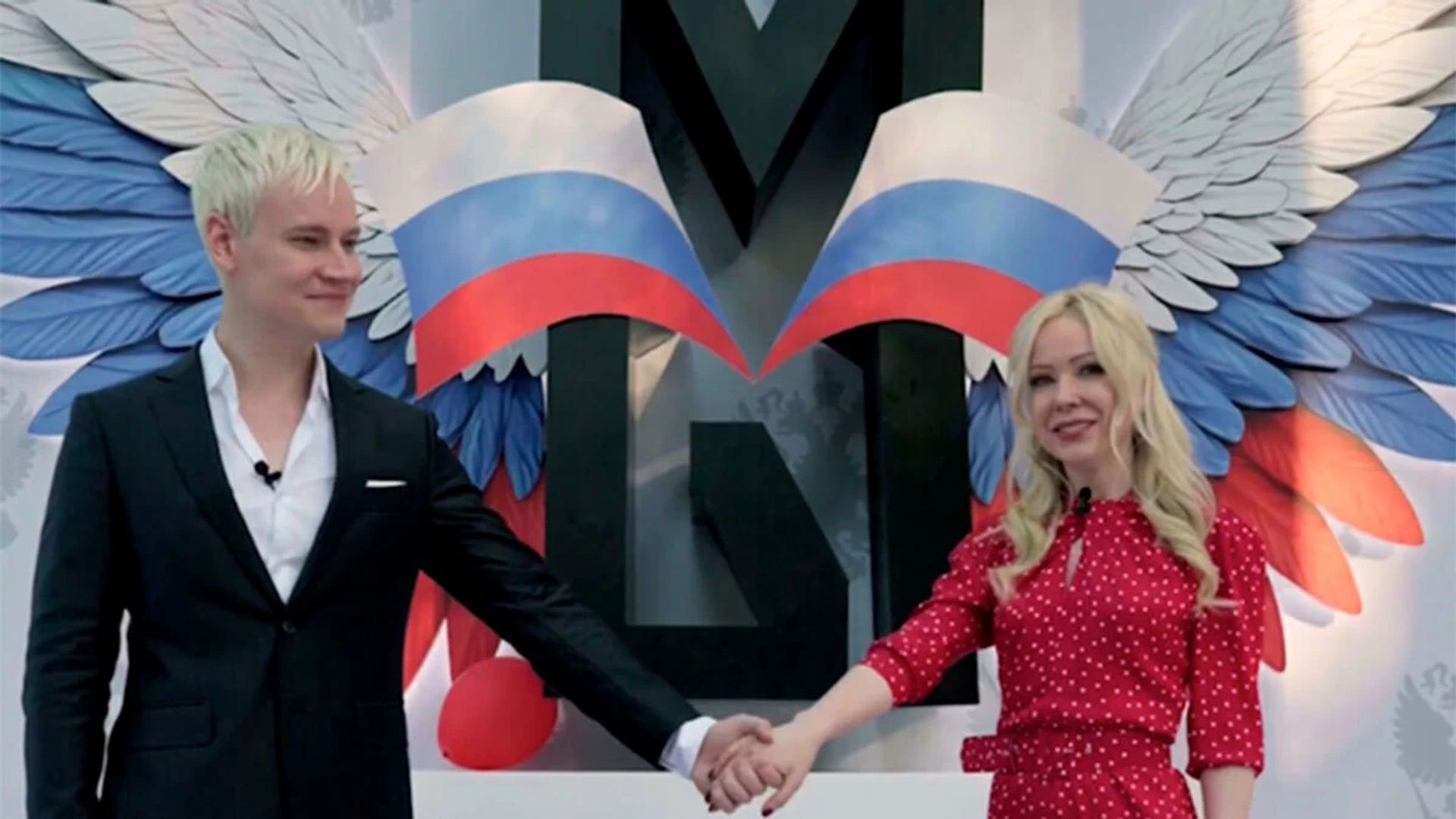 Шаман и Екатерина Мизулина держатся за руки на фоне российского фраза и слова МЫ