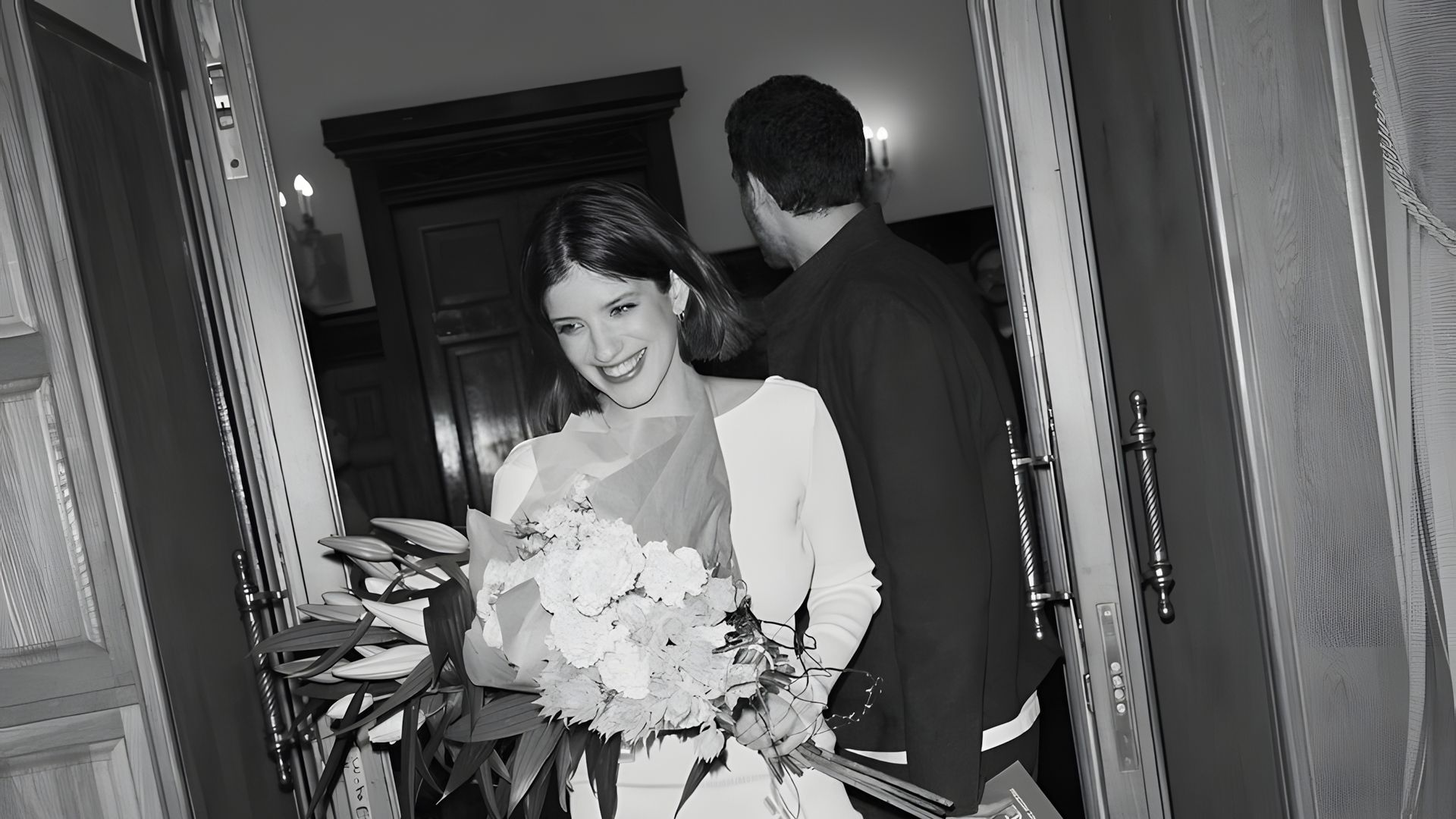Анна Чиповская стоит с букетом цветов в загсе, черно-бело фото