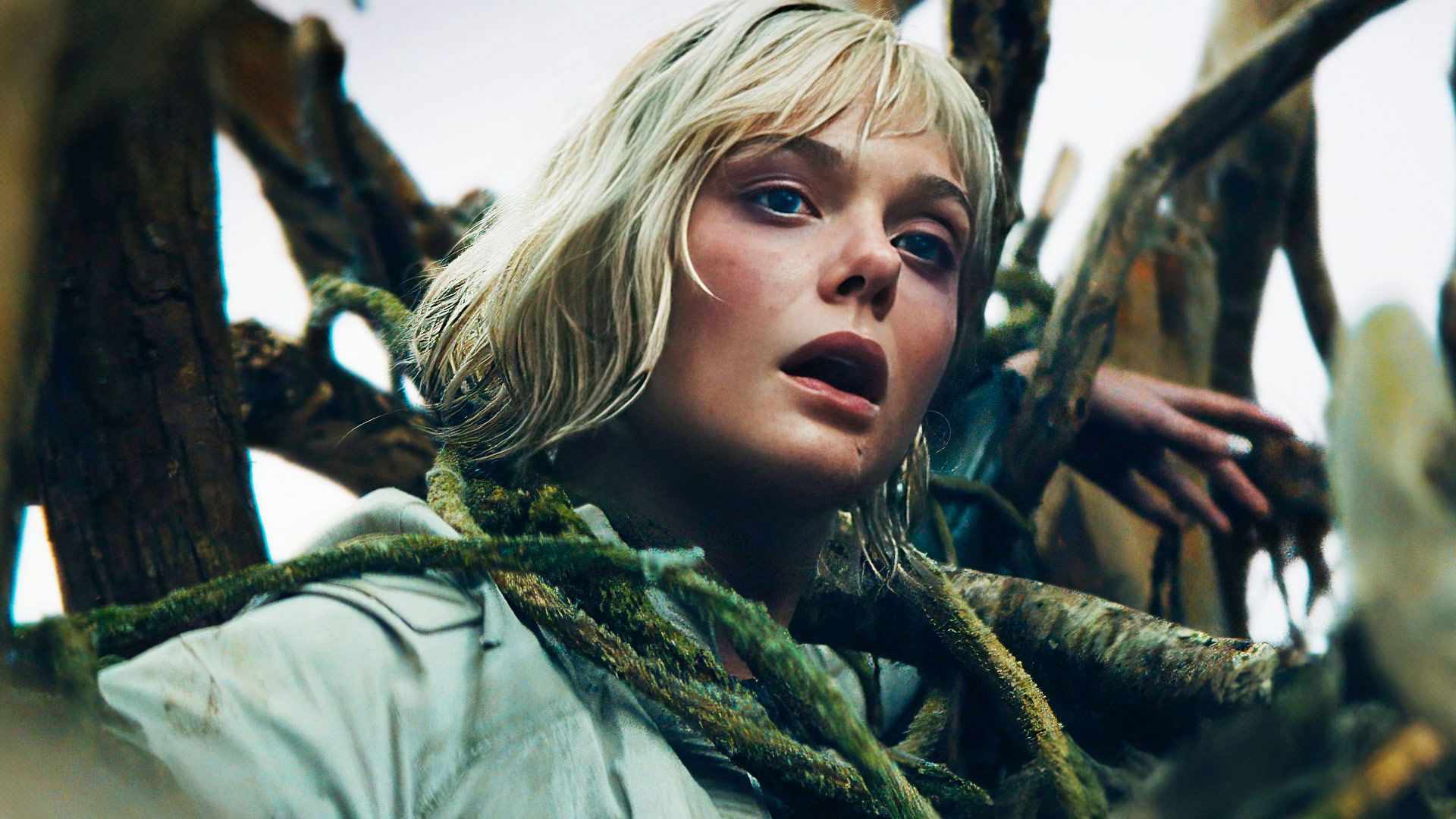 Эль Фаннинг с удивленным выражением лица, опутанная лианами