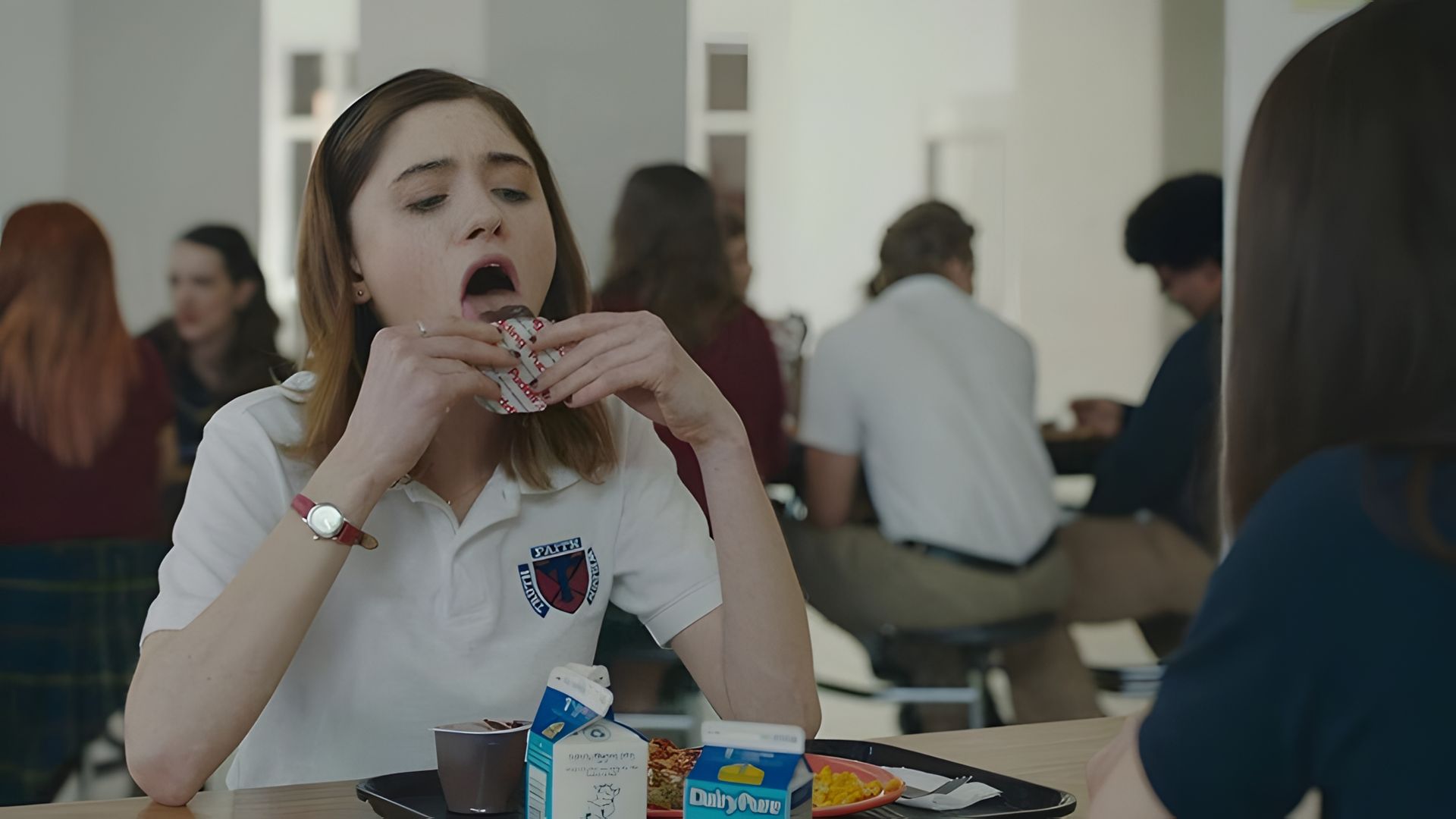 Наталия Дайер в школьной форме ест печенье