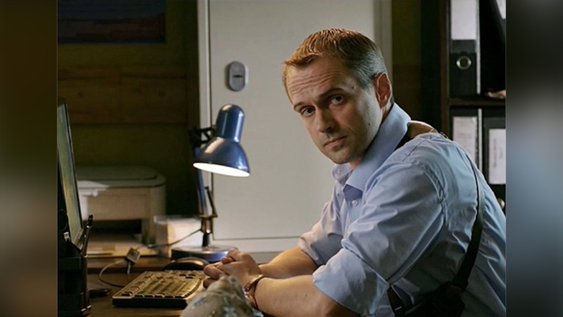 Алексей Комашко в полицейской форме сидит за столом