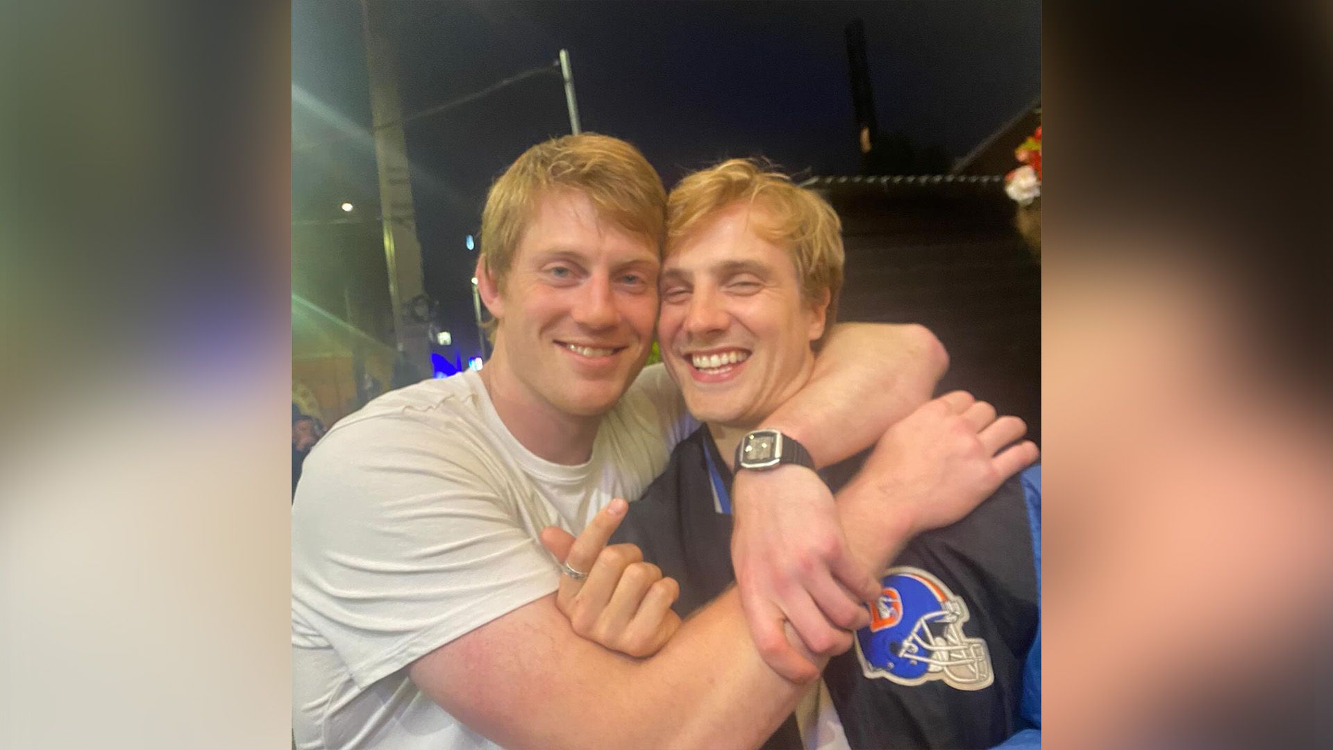 Питер Клэффи в белой футболке обнимает за шею смеющегося Генри Эштона в синей спортивной куртке