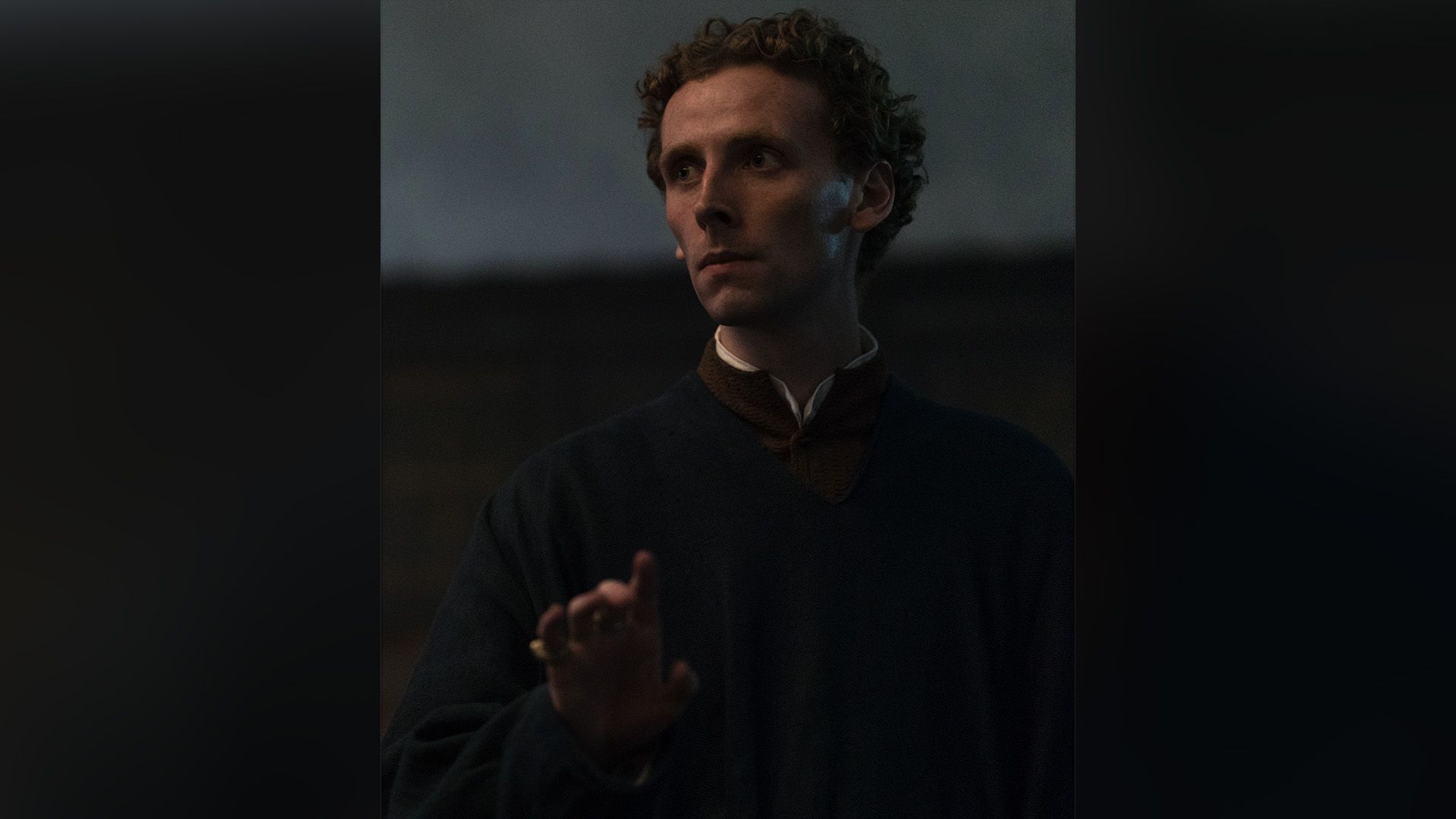 Эдвард Эшли в роли графа Кембриджа смотрит в сторону, приподняв руку