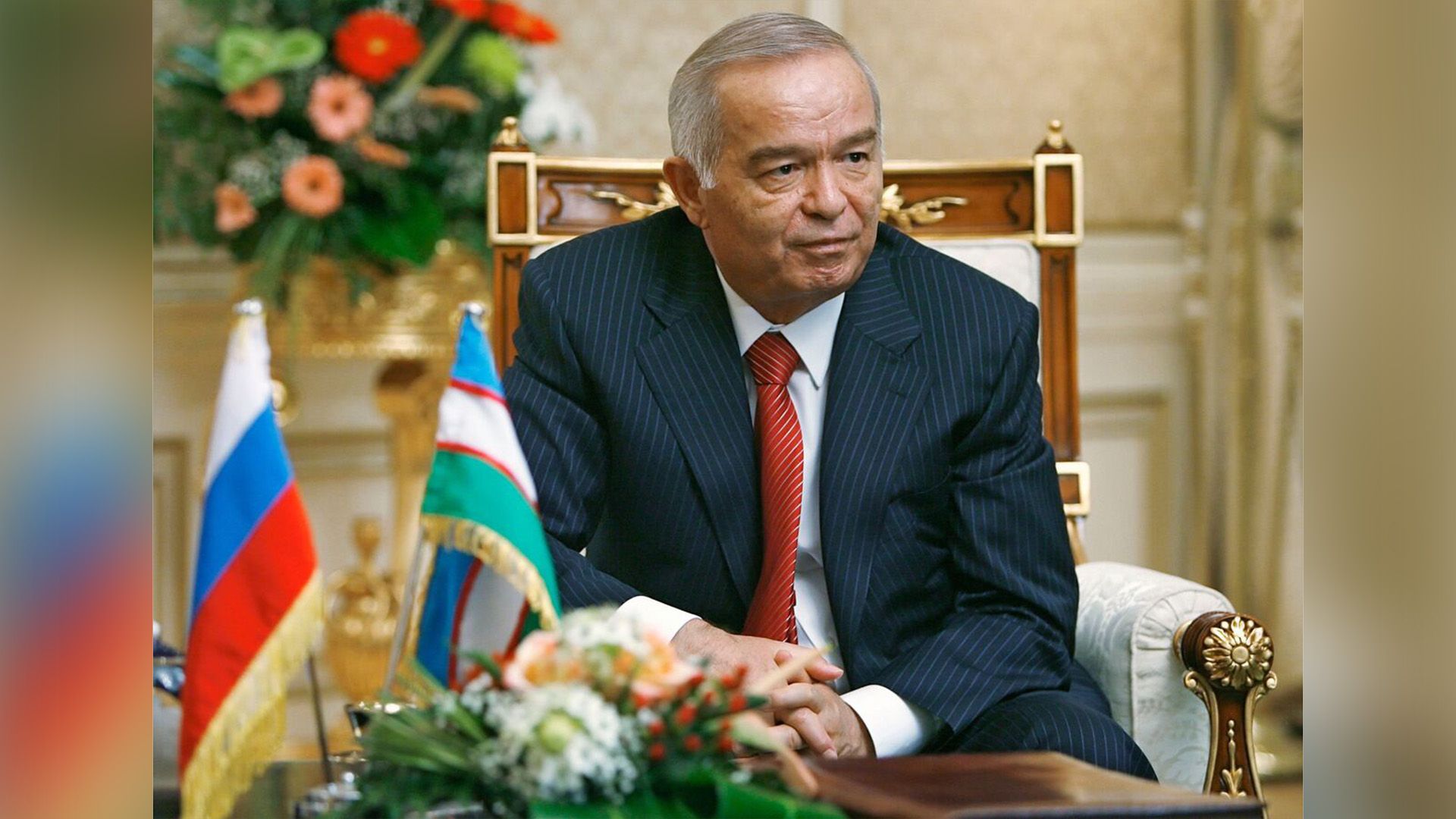 Ислам Каримов в синем костюме в полоску сидит в кресле, сцепив руки в замок